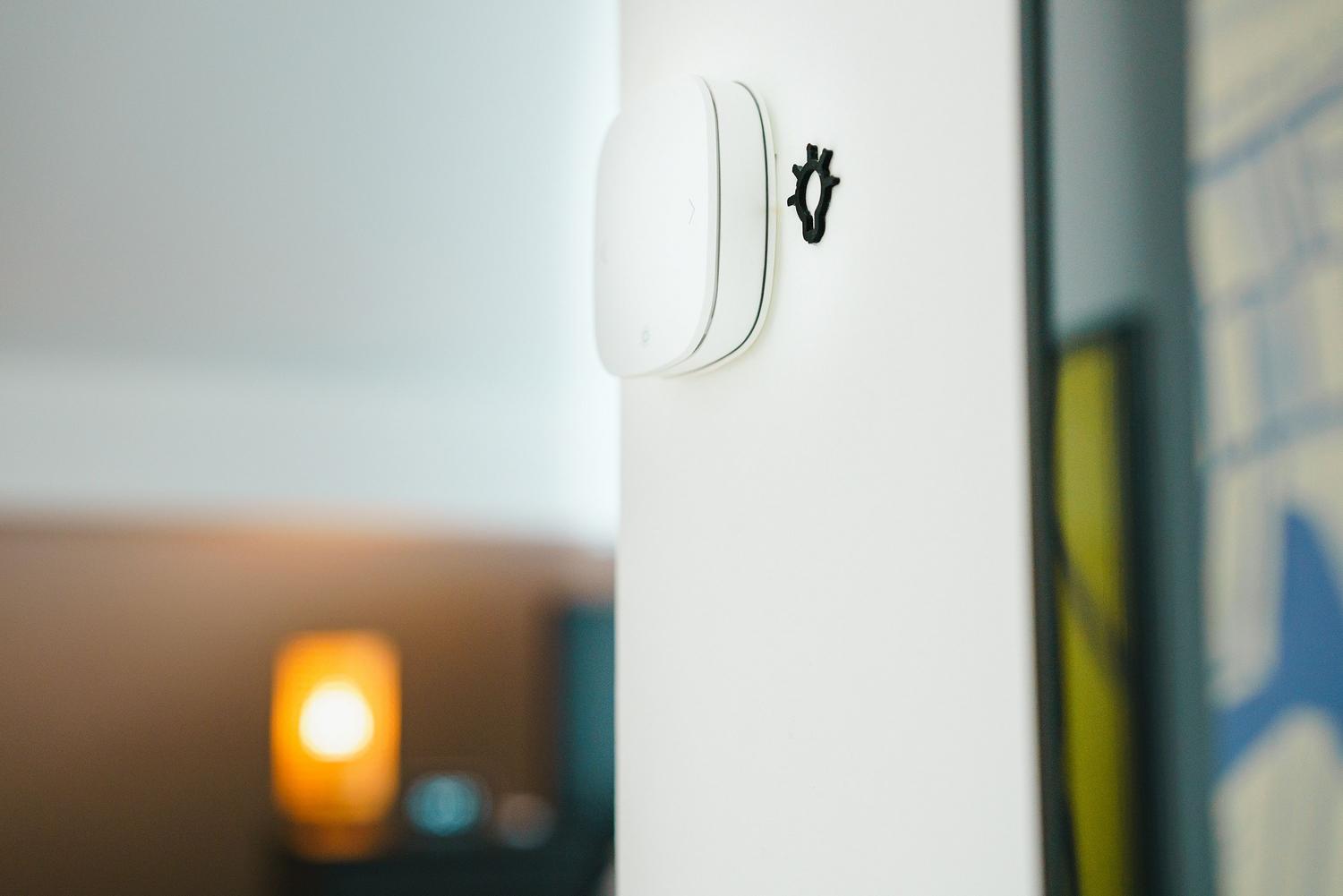 Interruptor inteligente minimalista instalado en la pared para el control de luces Zigbee.