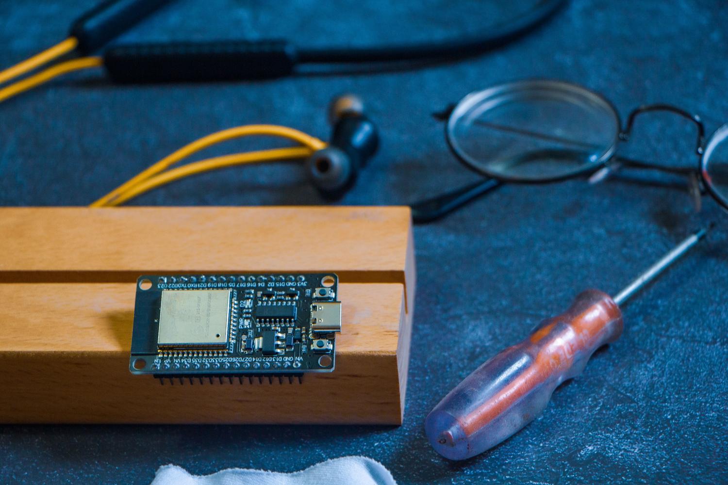 Placa de circuito electrónico y herramientas de precisión en un banco de trabajo, ilustrando la fase de prototipado técnico. Placa de circuito electrónico y herramientas de precisión en un banco de trabajo, ilustrando la fase de prototipado técnico.