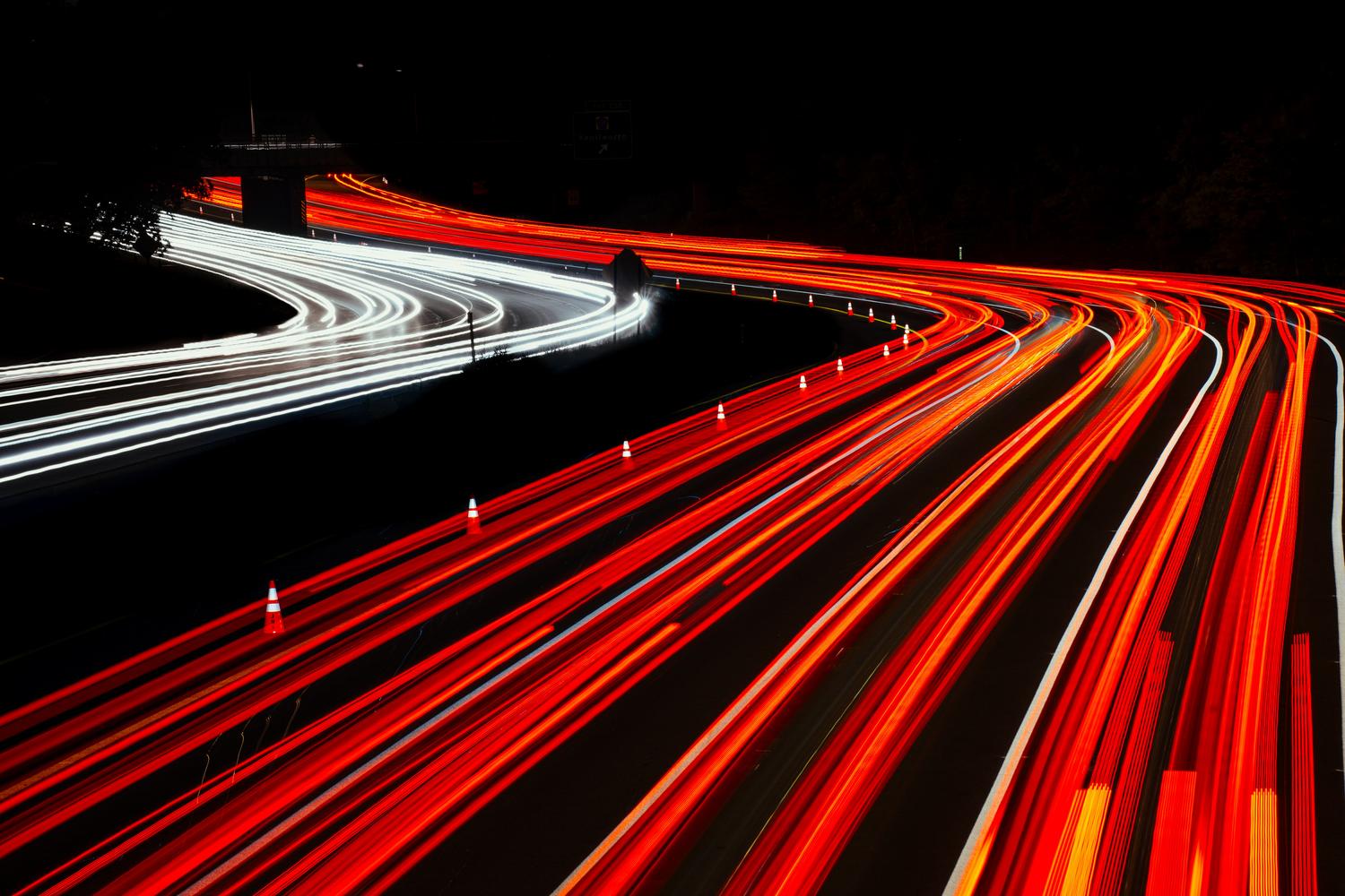 Rastros de luz en larga exposición simbolizando la alta velocidad de conexión a internet.