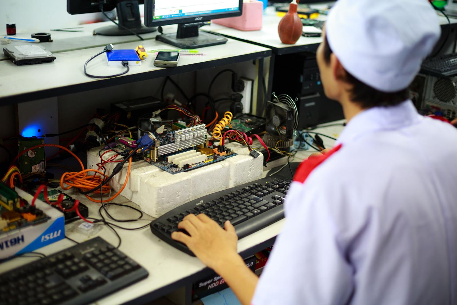 Técnico informático revisando componentes internos de hardware en un entorno de trabajo profesional.