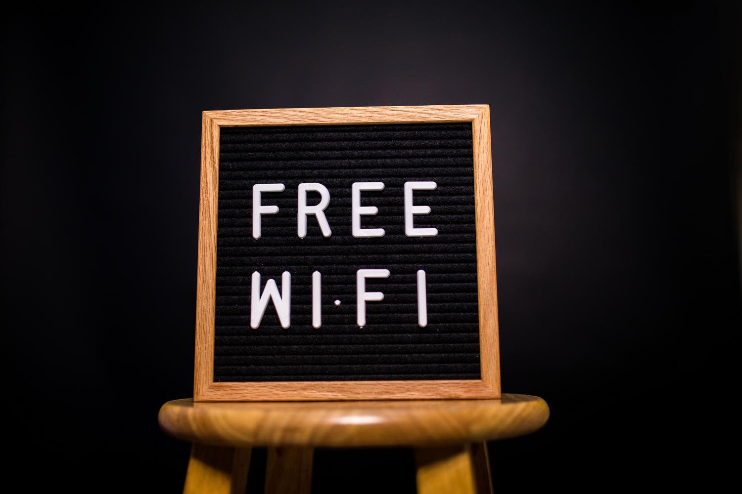 Letrero de madera con el texto 'Free Wi-Fi' representando el acceso a internet para invitados