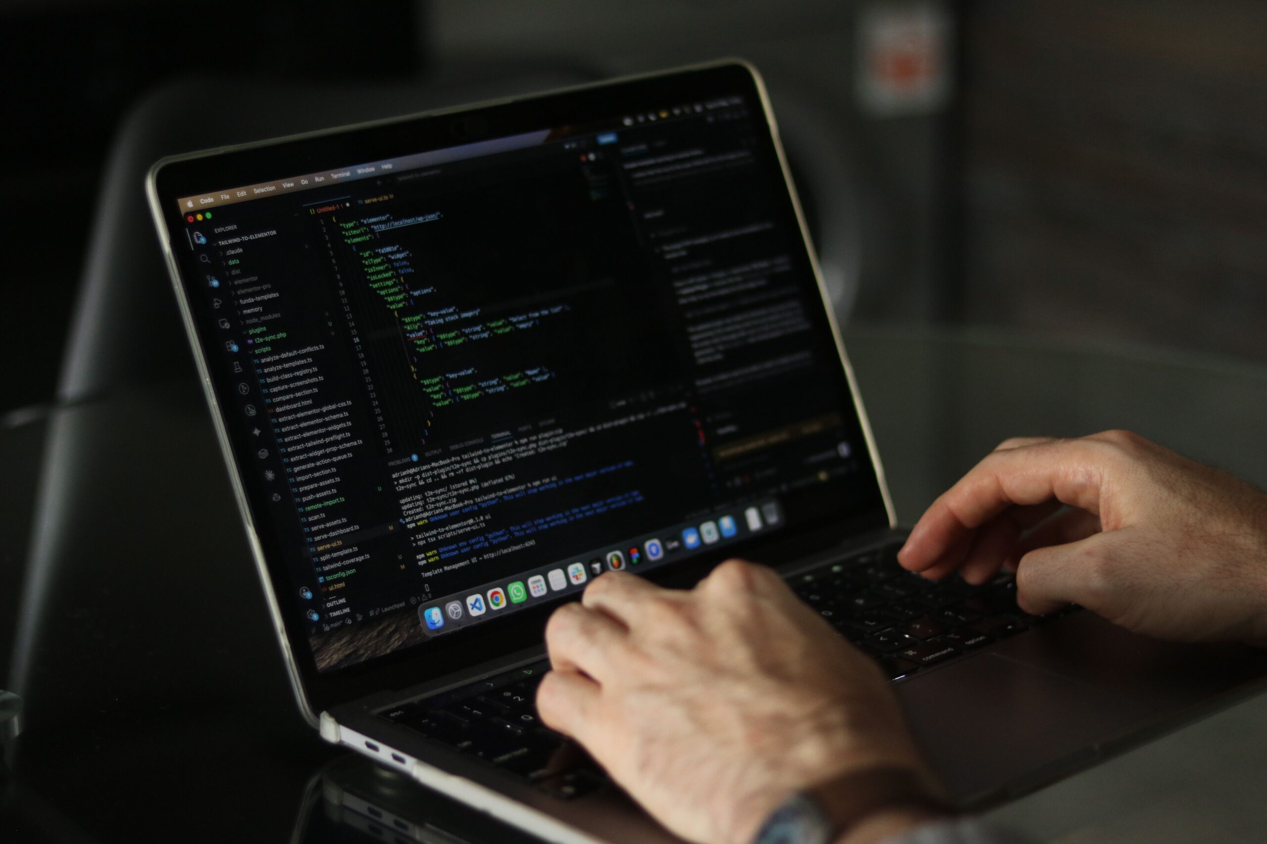 Primer plano de manos escribiendo código en un editor de texto con terminal abierta, ideal para ilustrar la edición de variables.