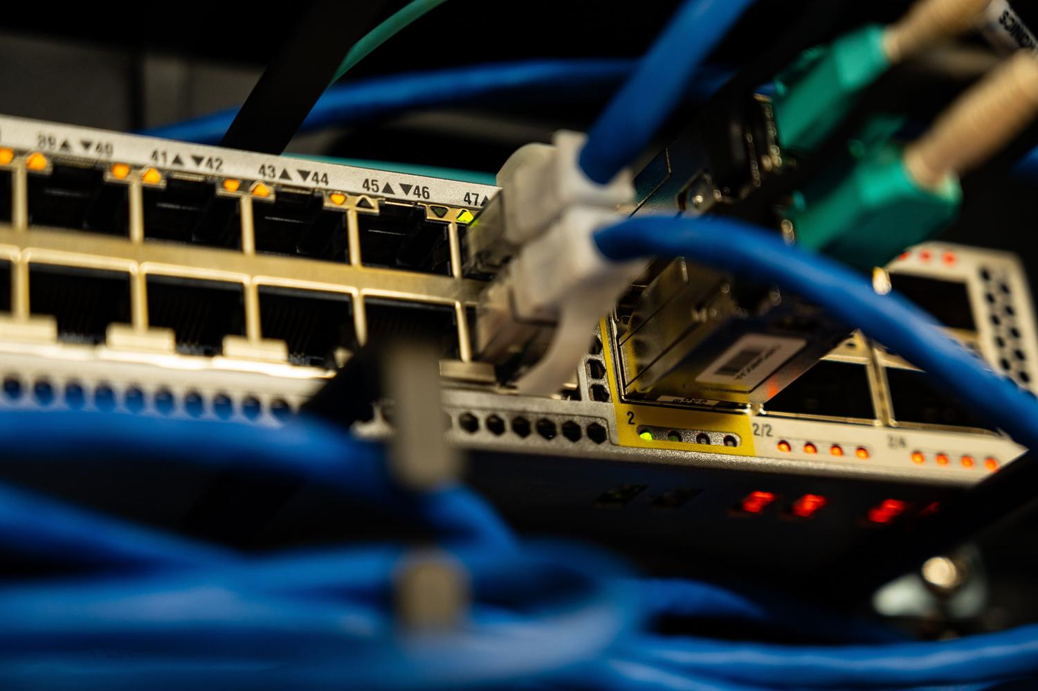 Primer plano de cables Ethernet conectados a un switch de red, ilustrando la infraestructura física necesaria para Wake on LAN.