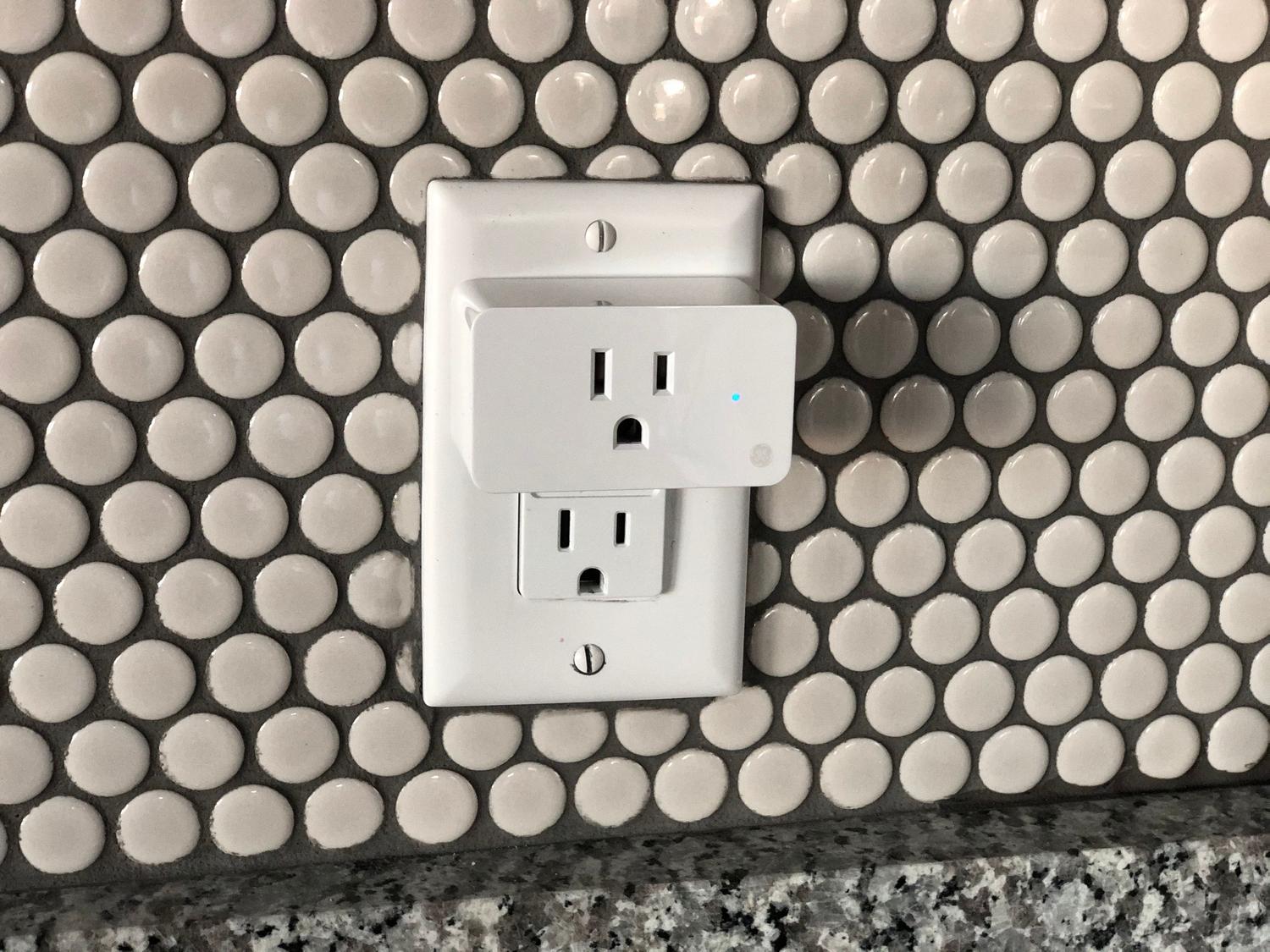 Primer plano de un enchufe inteligente conectado a la pared, ilustrando el hardware a intervenir. Primer plano de un enchufe inteligente conectado a la pared, ilustrando el hardware a intervenir.