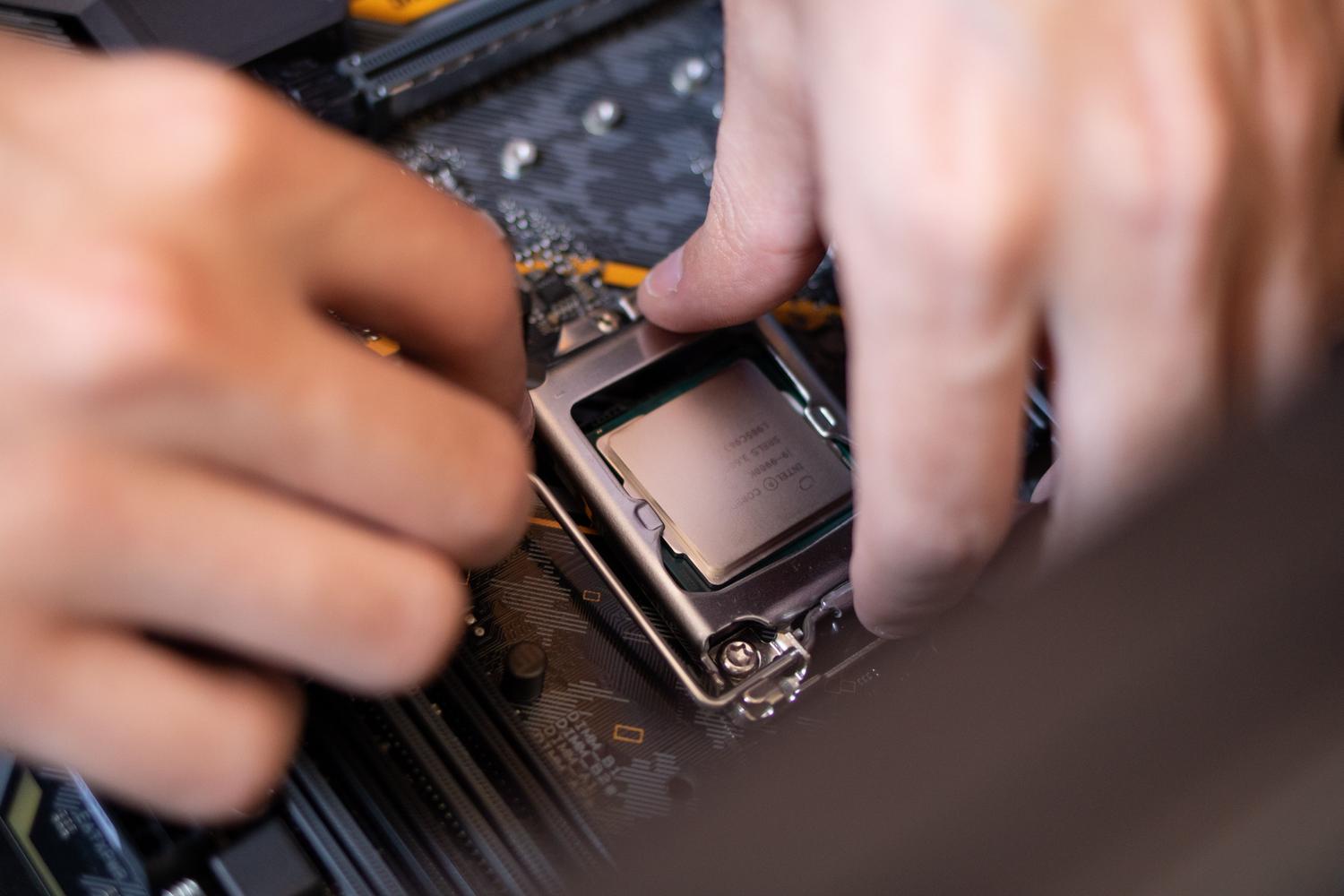 Manos instalando un procesador en la placa base de un ordenador, representando el proceso técnico. Manos instalando un procesador en la placa base de un ordenador, representando el proceso técnico.