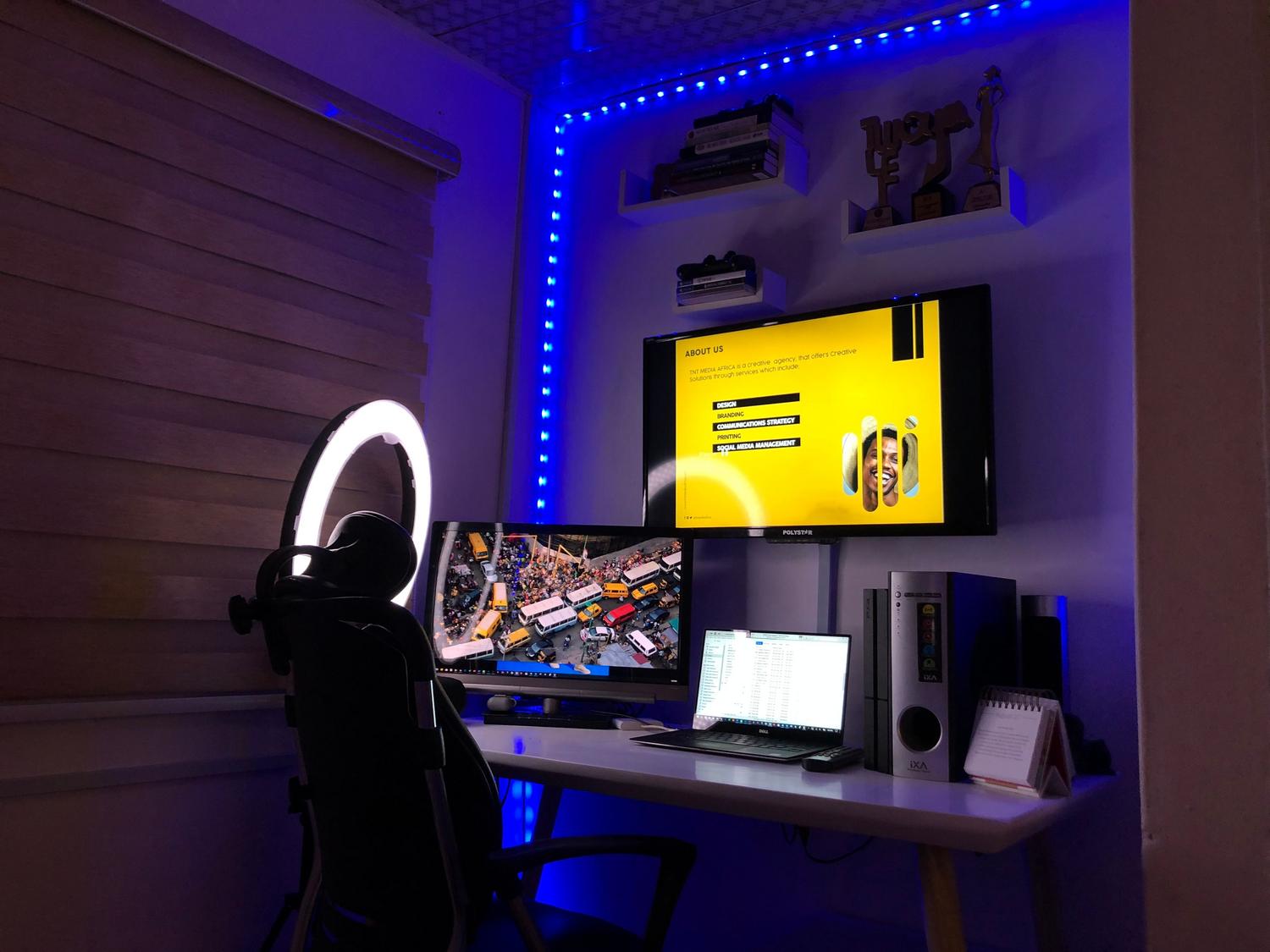 Configuración de oficina en casa con doble monitor y luz ambiental para optimizar la productividad.
