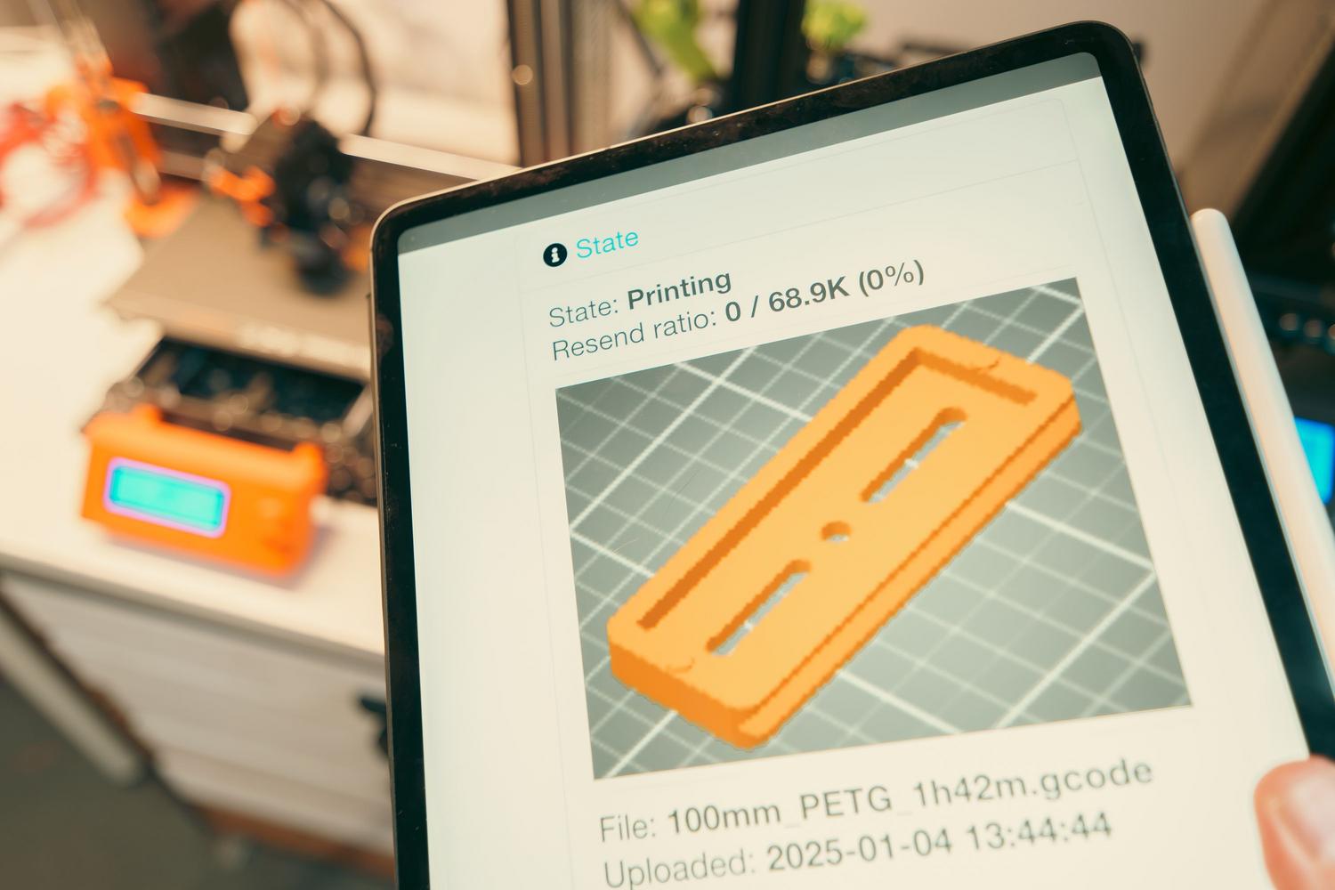 Tablet mostrando el software de control de una impresión 3D de una carcasa de teclado. Tablet mostrando el software de control de una impresión 3D de una carcasa de teclado.