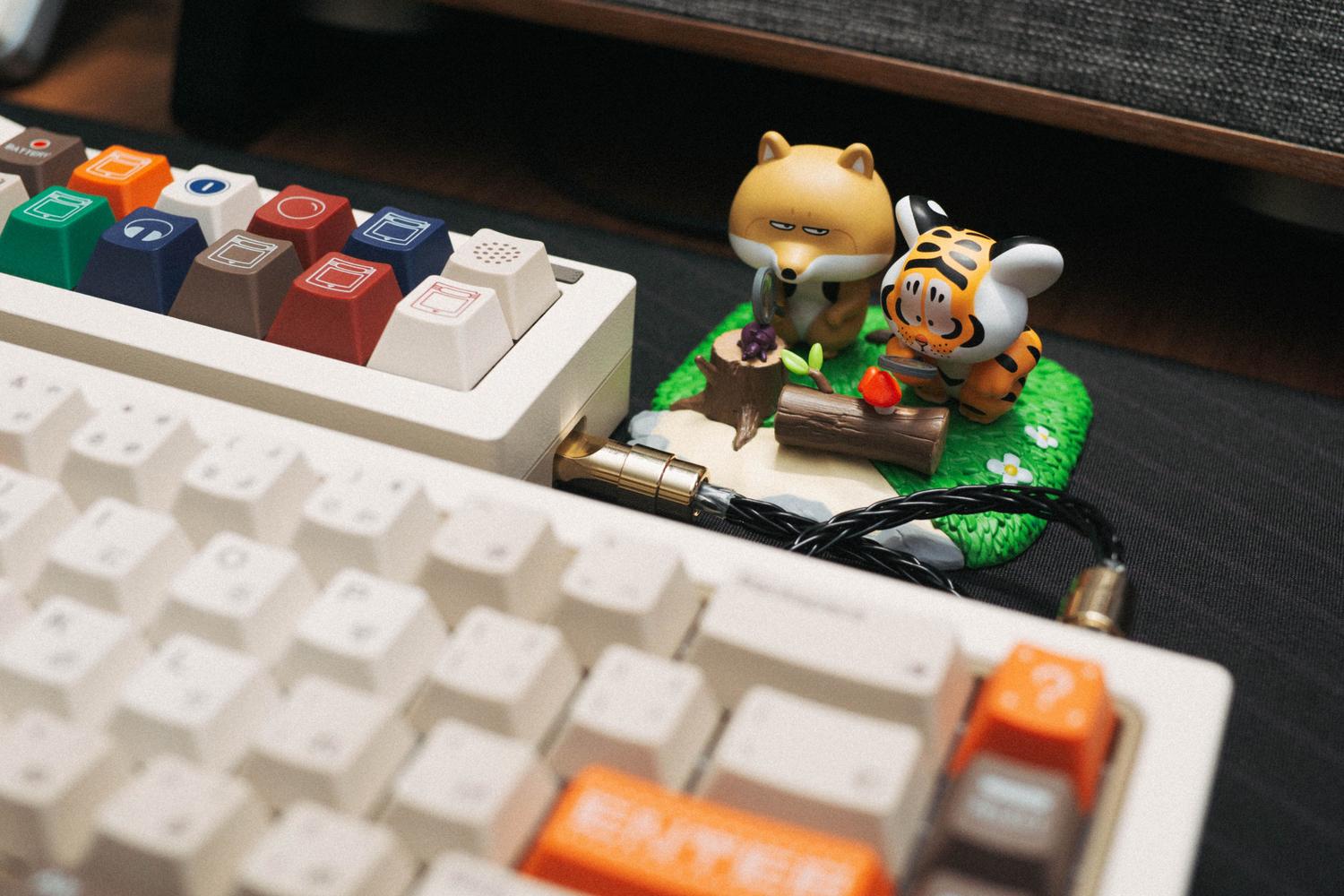 Setup de teclado mecánico personalizado con macropad, cable coiled y elementos decorativos. Setup de teclado mecánico personalizado con macropad, cable coiled y elementos decorativos.