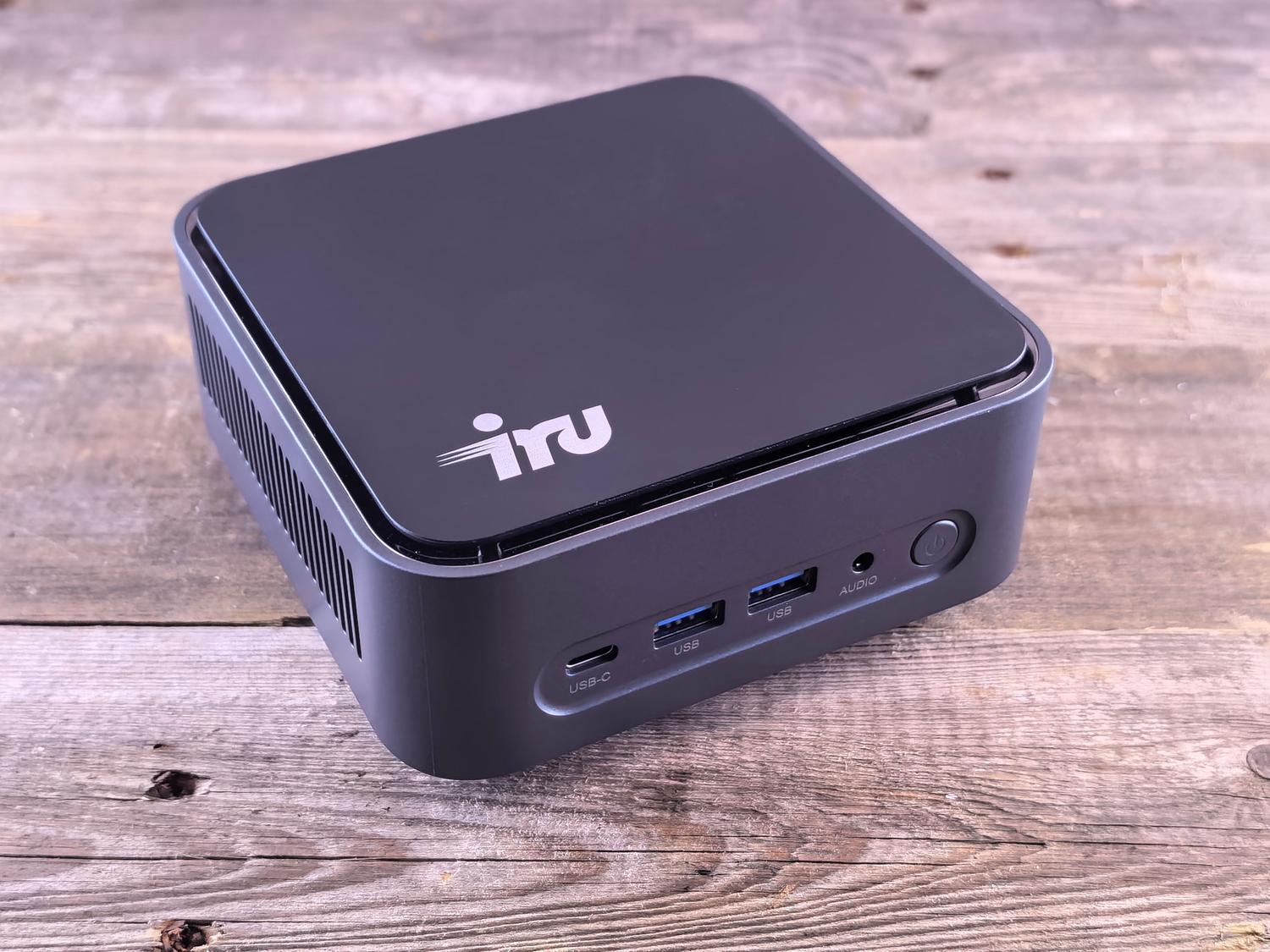Mini PC compacto y moderno sobre una superficie de madera, ideal para servir como servidor de Frigate y Home Assistant.