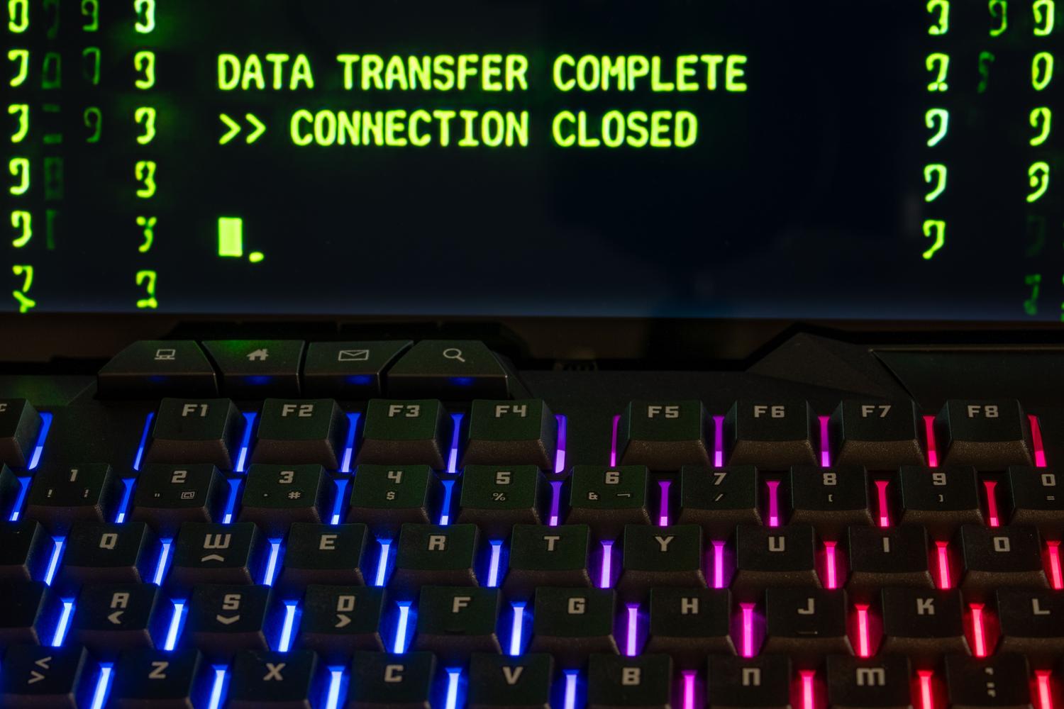 Teclado mecánico con iluminación RGB y pantalla de proceso completado, representando la automatización de instalaciones.