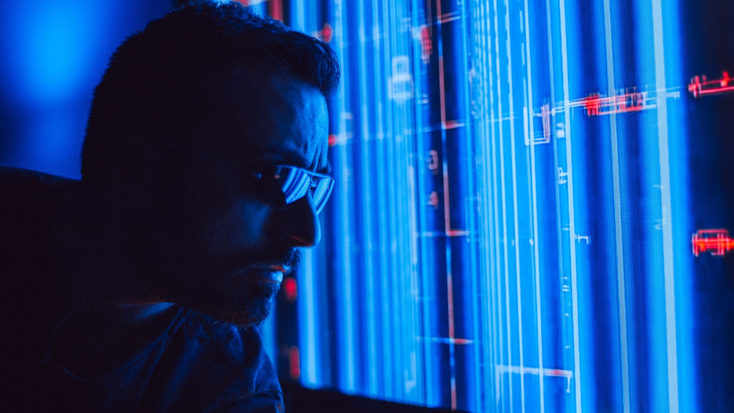 Hombre utilizando gafas inteligentes con una pantalla holográfica azul, representando la IA vestible. Hombre utilizando gafas inteligentes con una pantalla holográfica azul, representando la IA vestible.