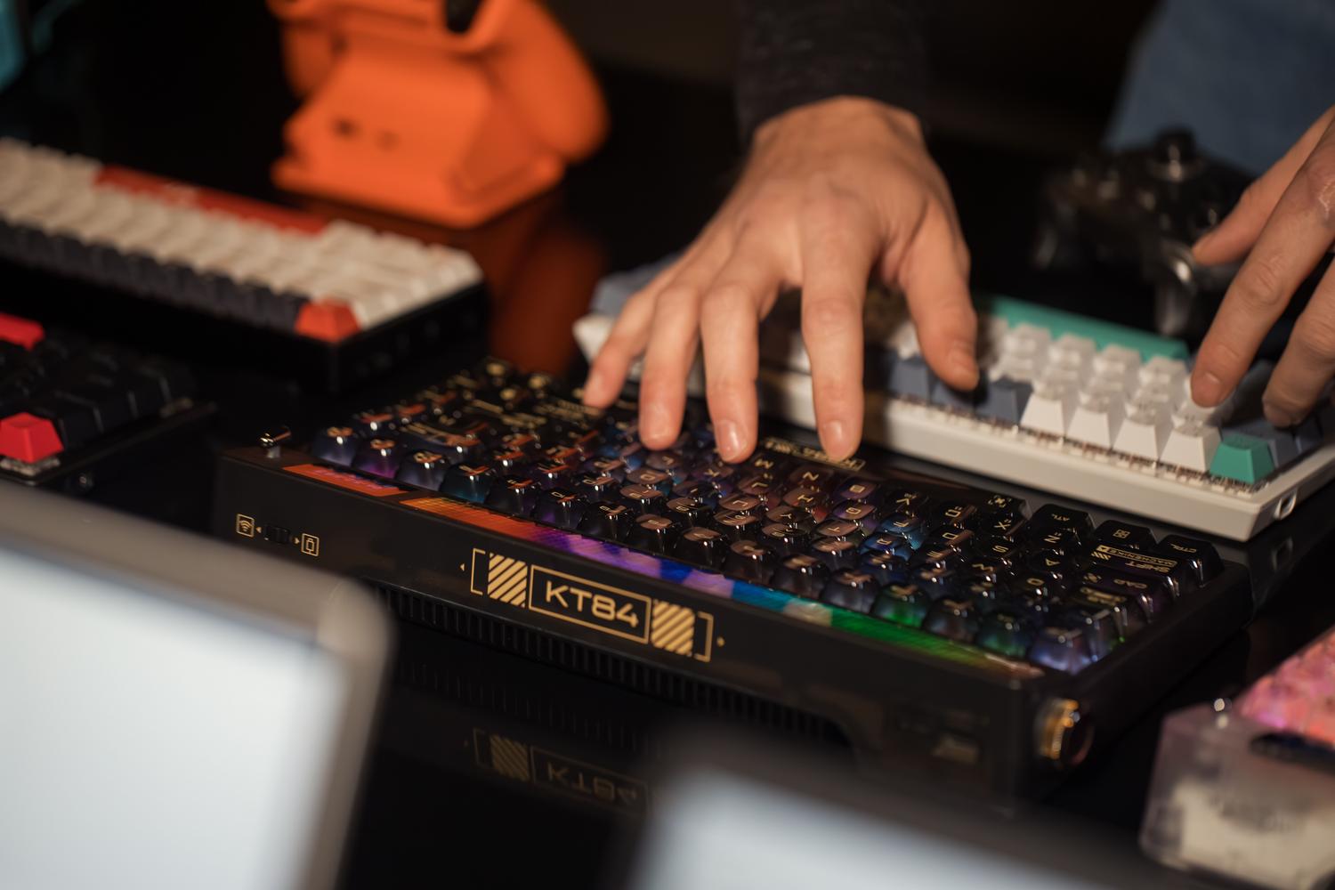 Manos escribiendo en un teclado mecánico personalizado con keycaps coloridas, mostrando el resultado final de una configuración optimizada.