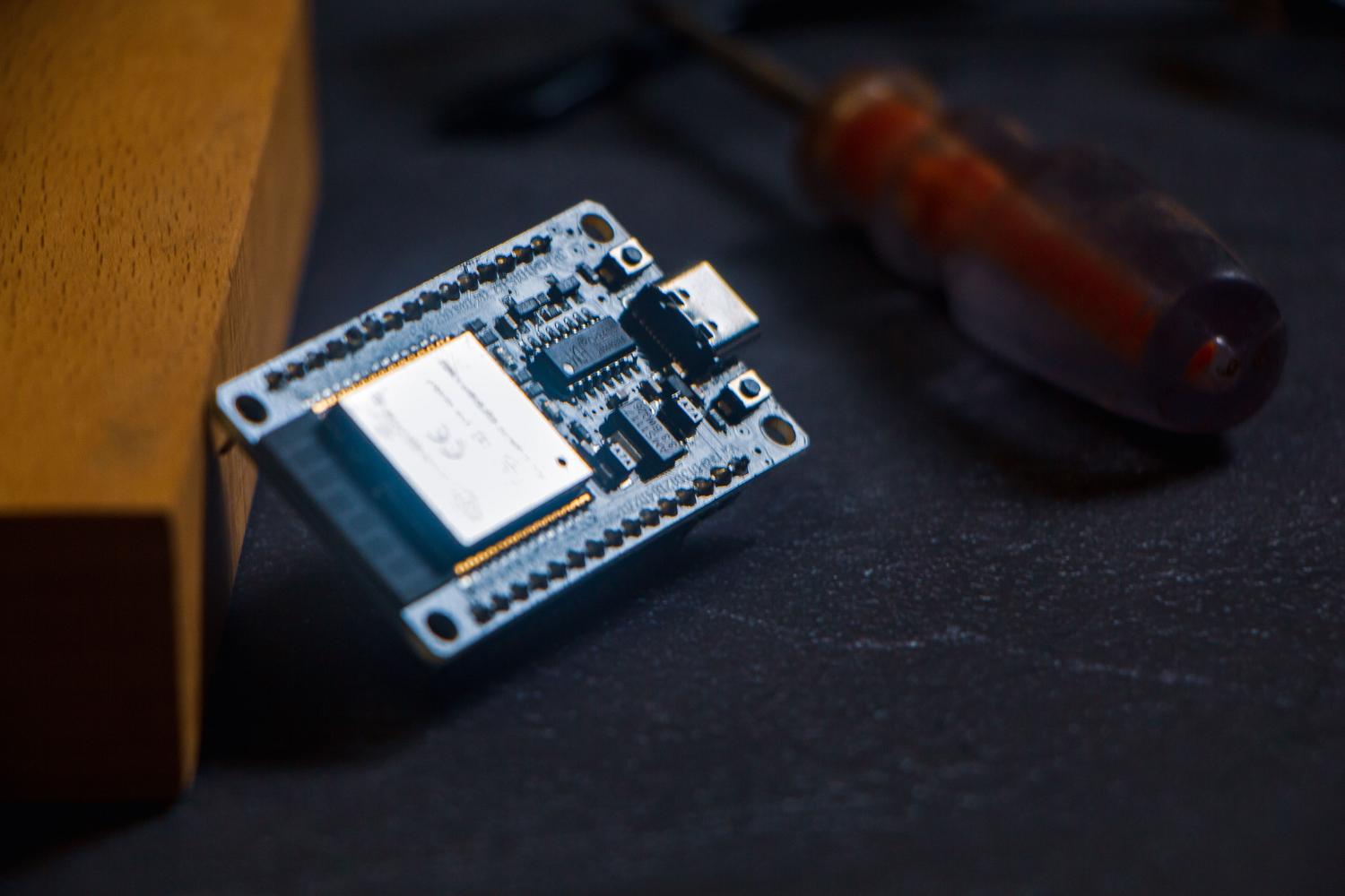 Primer plano de un microcontrolador ESP32 sobre una superficie de trabajo, el cerebro electrónico del proyecto de monitoreo.