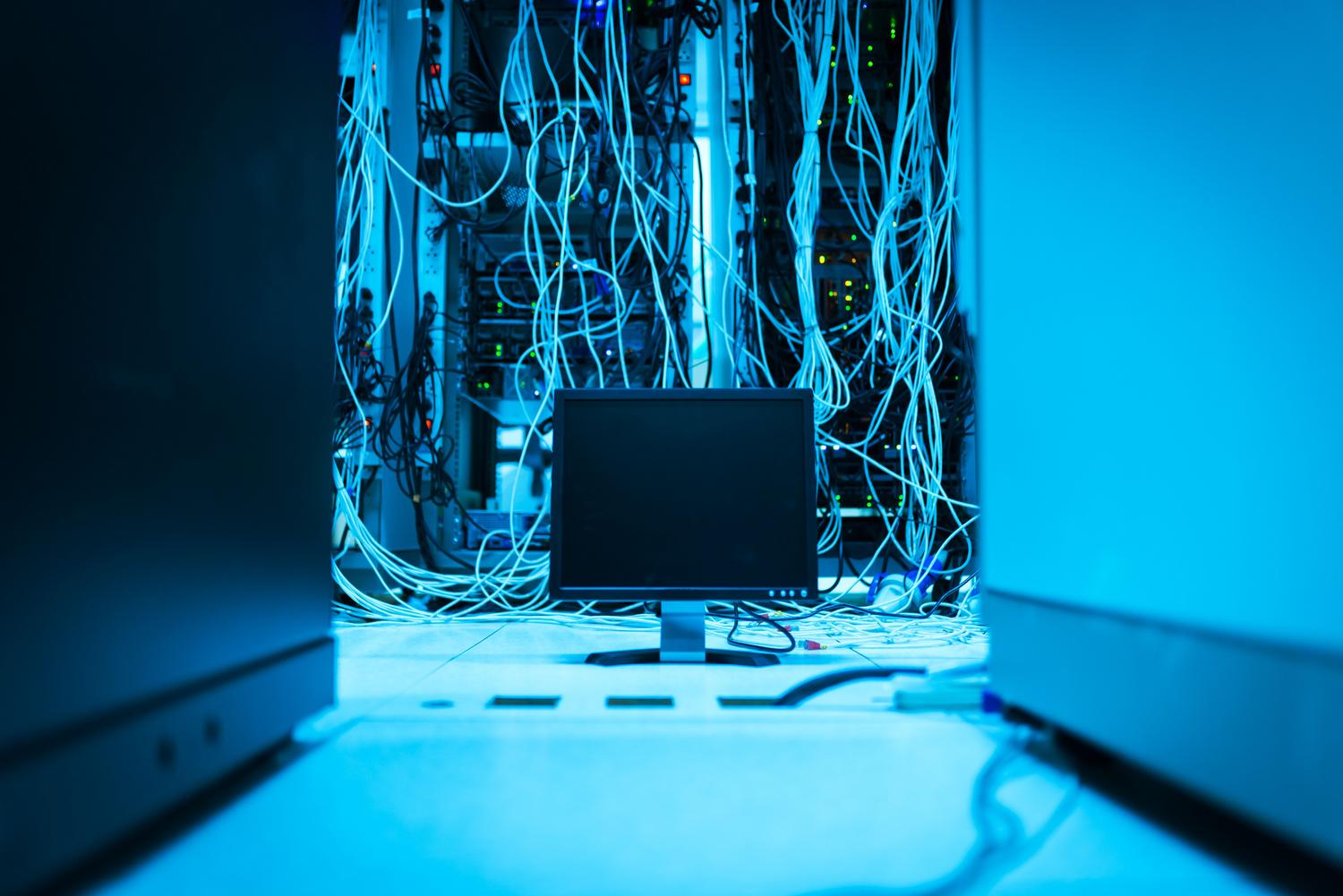 Infraestructura de red con cables y un monitor en un entorno técnico.