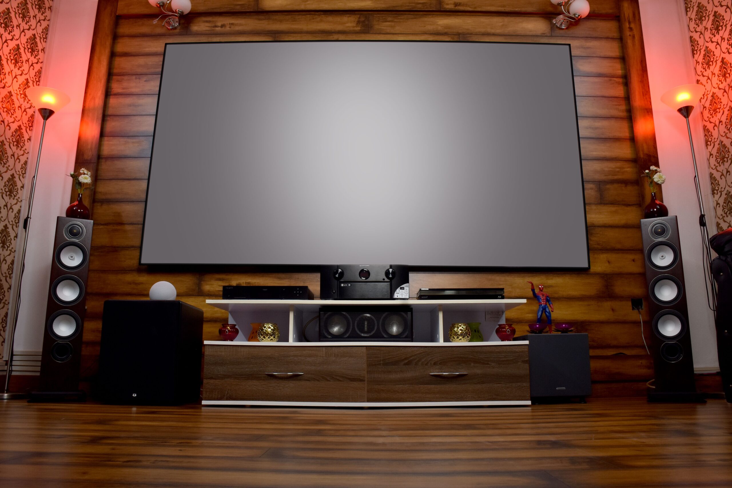 Configuración de cine en casa con pantalla de proyección y equipo de audio moderno.