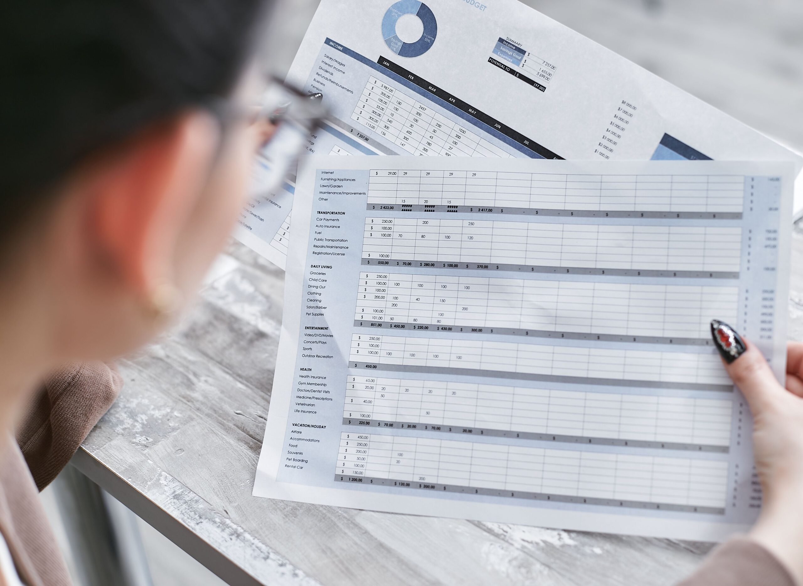 Mujer de negocios revisando hojas de cálculo financieras con gráficos en una oficina. Mujer de negocios revisando hojas de cálculo financieras con gráficos en una oficina.