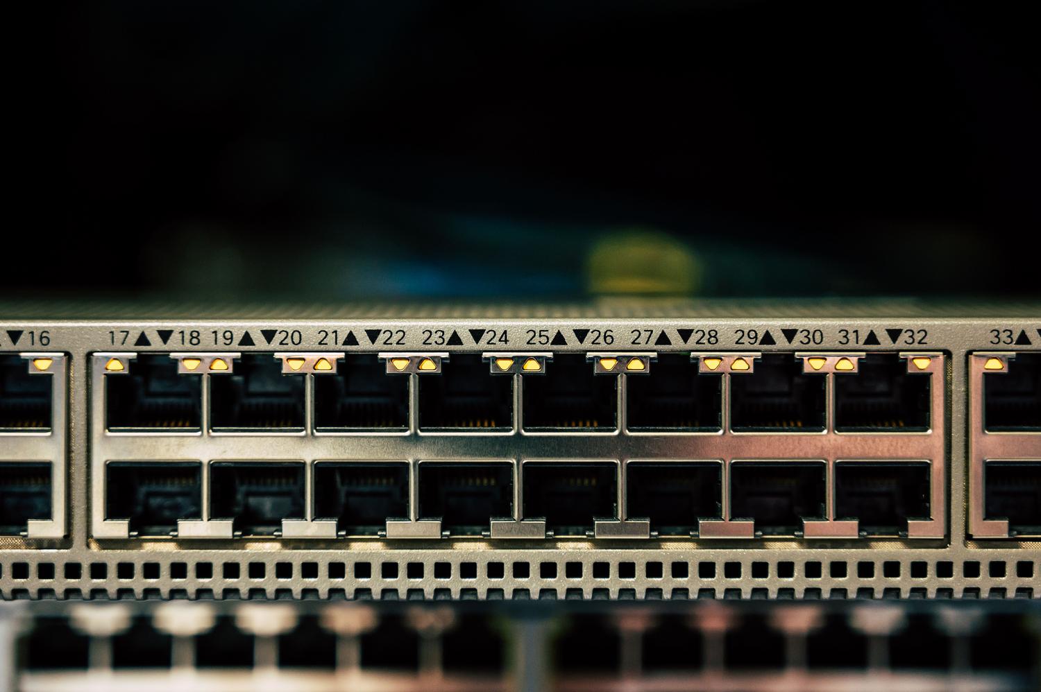 Detalle de un switch de red con indicadores LED activos, simbolizando el monitoreo de red y la gestión de direcciones IP.