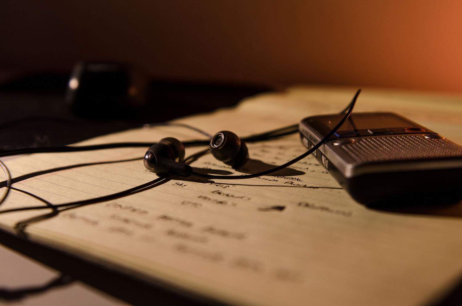 Grabadora de voz digital, auriculares y cuaderno con notas, ideal para representar el trabajo de periodistas y estudiantes