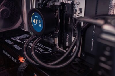 Vista interna de un PC gaming con un sistema de refrigeración líquida que muestra las temperaturas en tiempo real en una pantalla LCD.