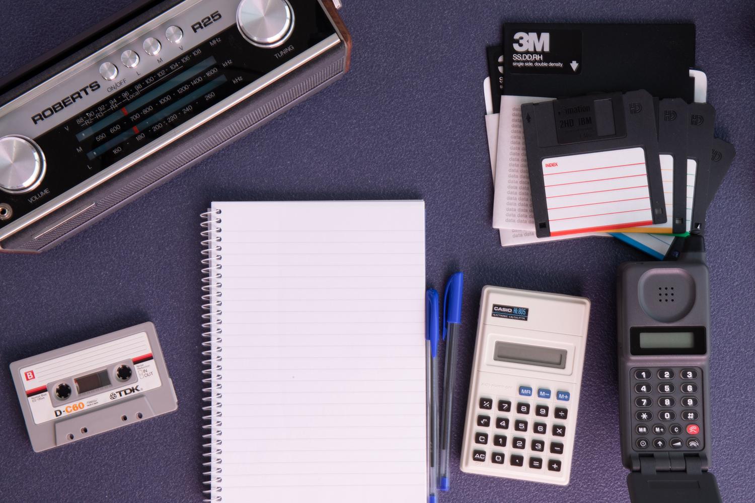 Vista cenital de diversos gadgets tecnológicos retro, aportando un contexto visual de nostalgia y sostenibilidad tecnológica.