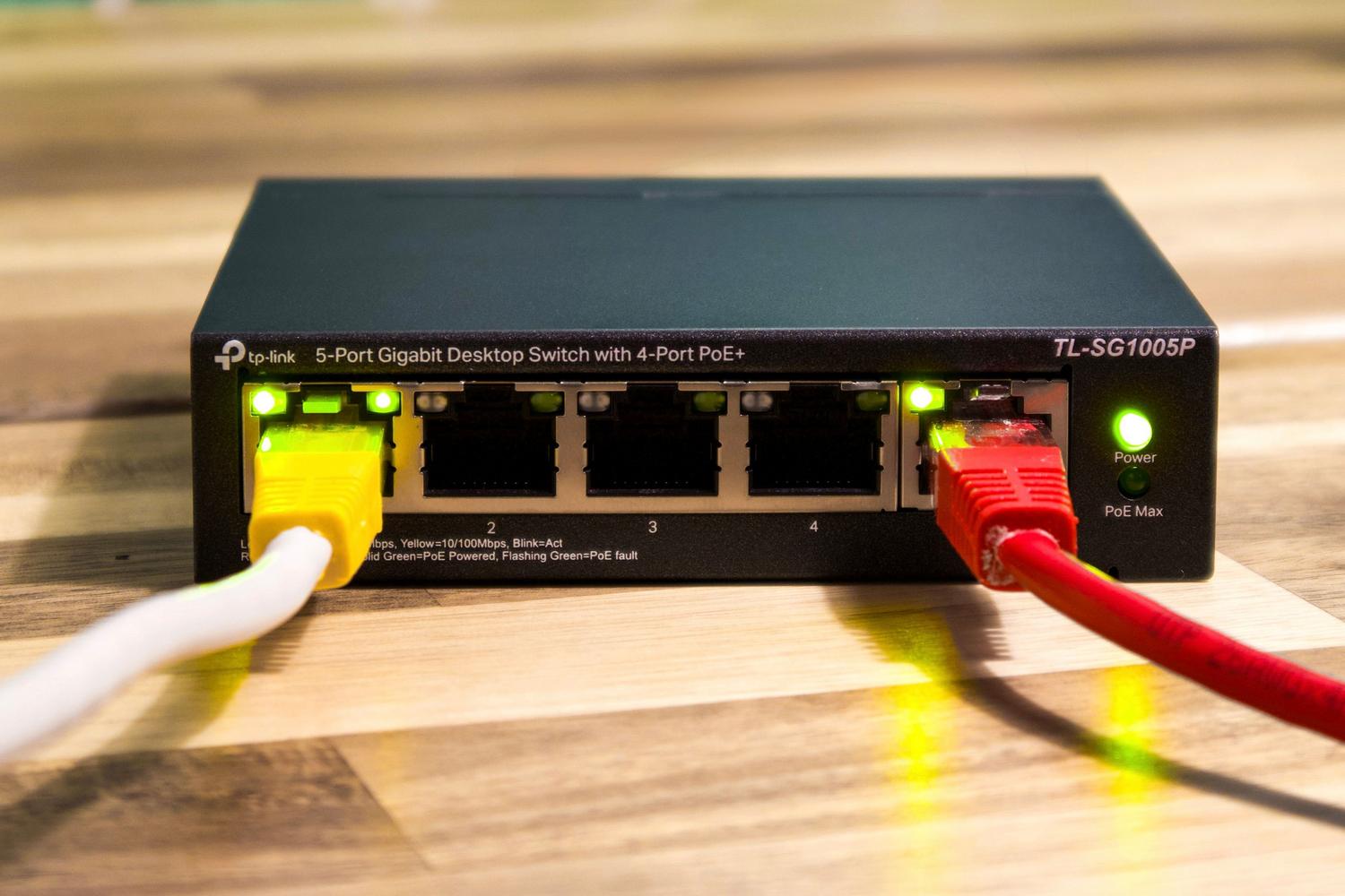 Switch de red Gigabit con cables Ethernet conectados, ilustrando la expansión de puertos de red
