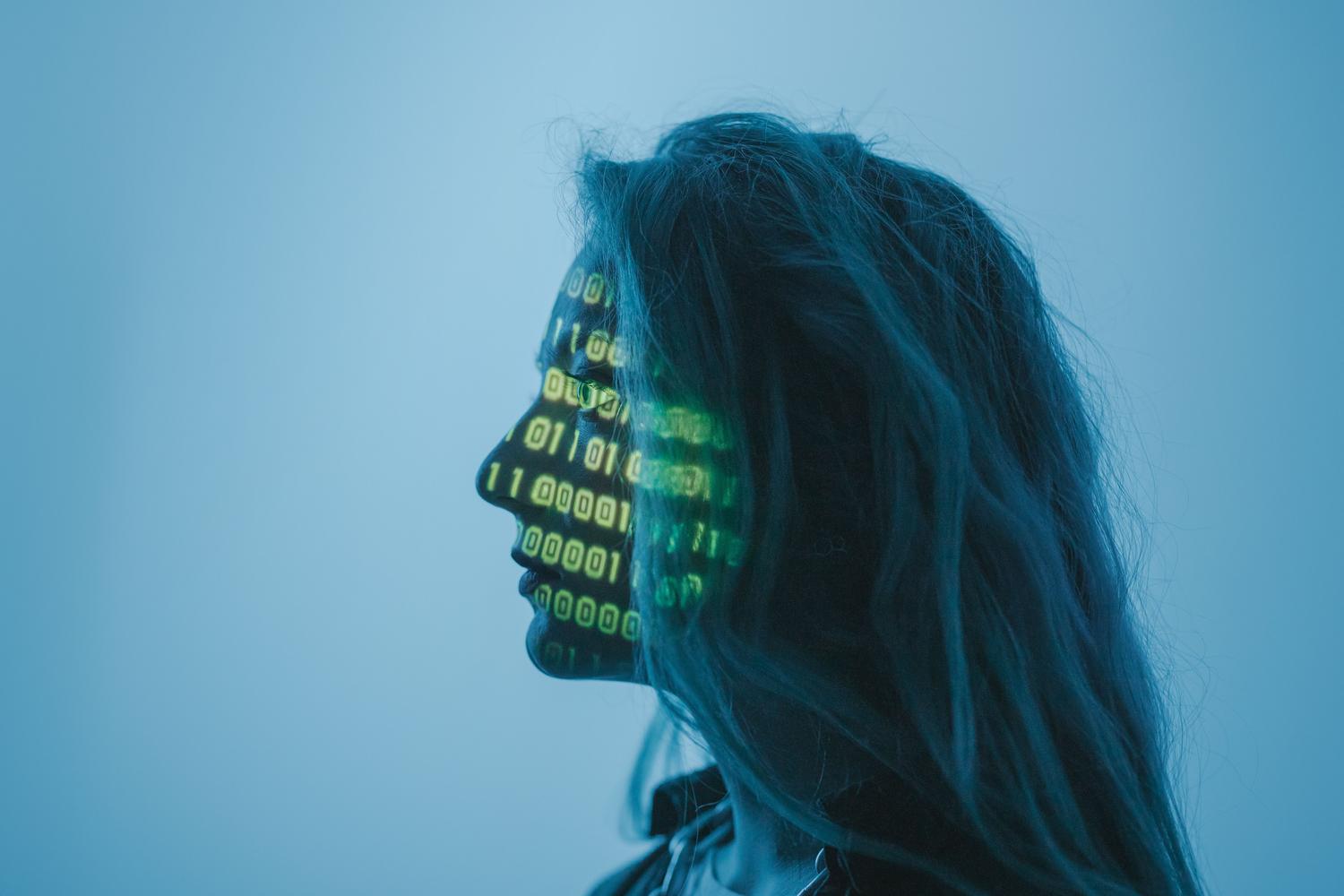 Concepto visual de inteligencia artificial con código binario proyectado sobre el rostro de una persona.