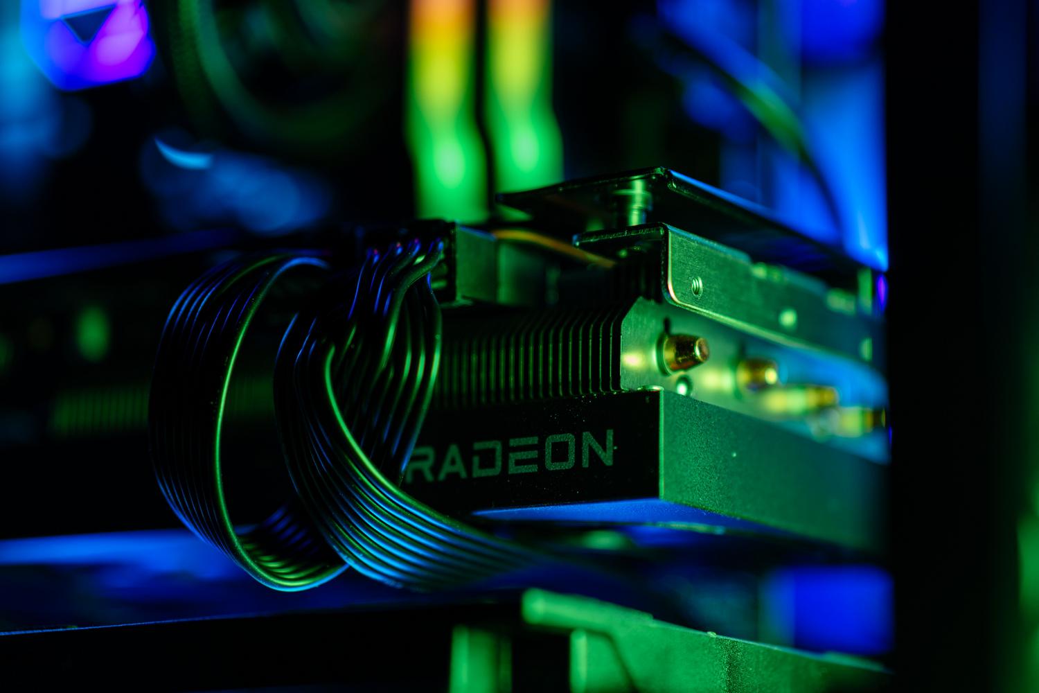 Detalle de una tarjeta gráfica Radeon de AMD con iluminación RGB en el interior de un PC, ilustrando la IA en el escritorio y portátiles.