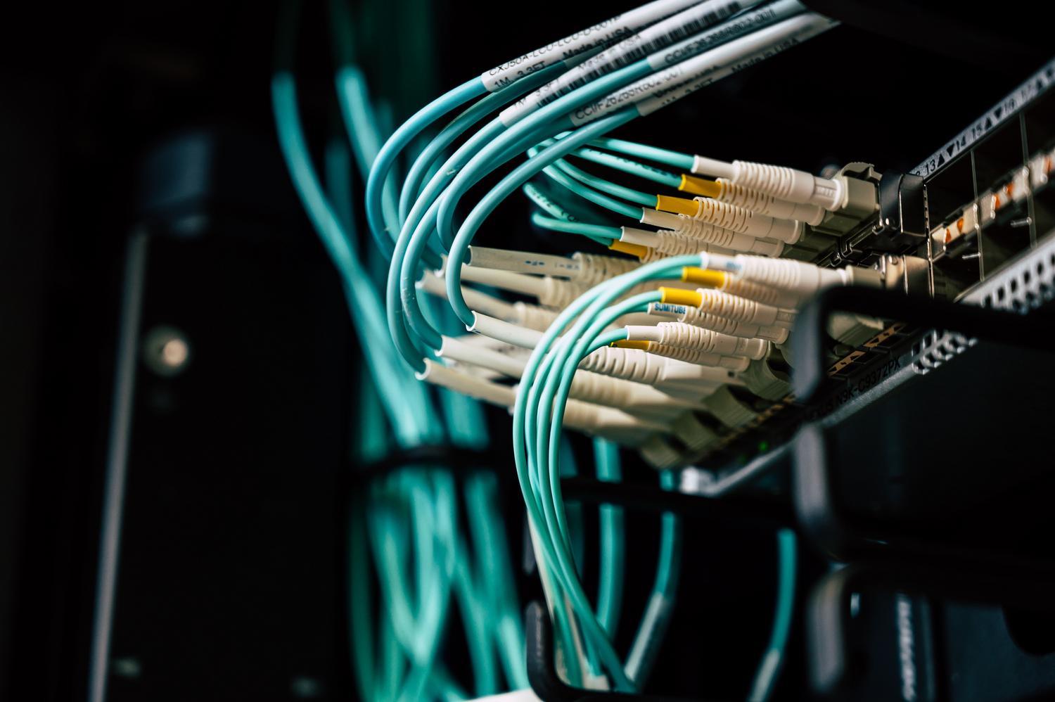 Infraestructura de red en un centro de datos con múltiples cables Ethernet organizados en un rack de servidores.
