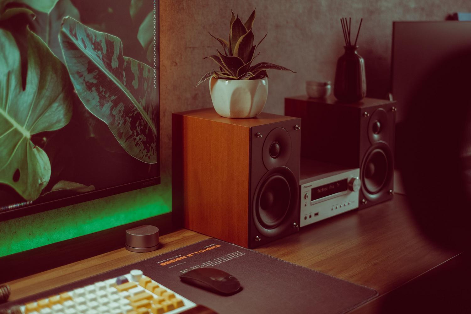 Configuración de escritorio moderna con altavoces de madera, útil para secciones sobre salida de audio externa