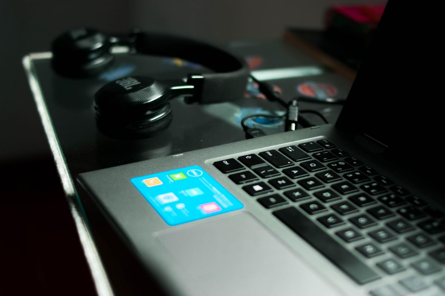 Primer plano de un portátil y auriculares sobre un escritorio, ideal para ilustrar la comprobación de hardware de audio