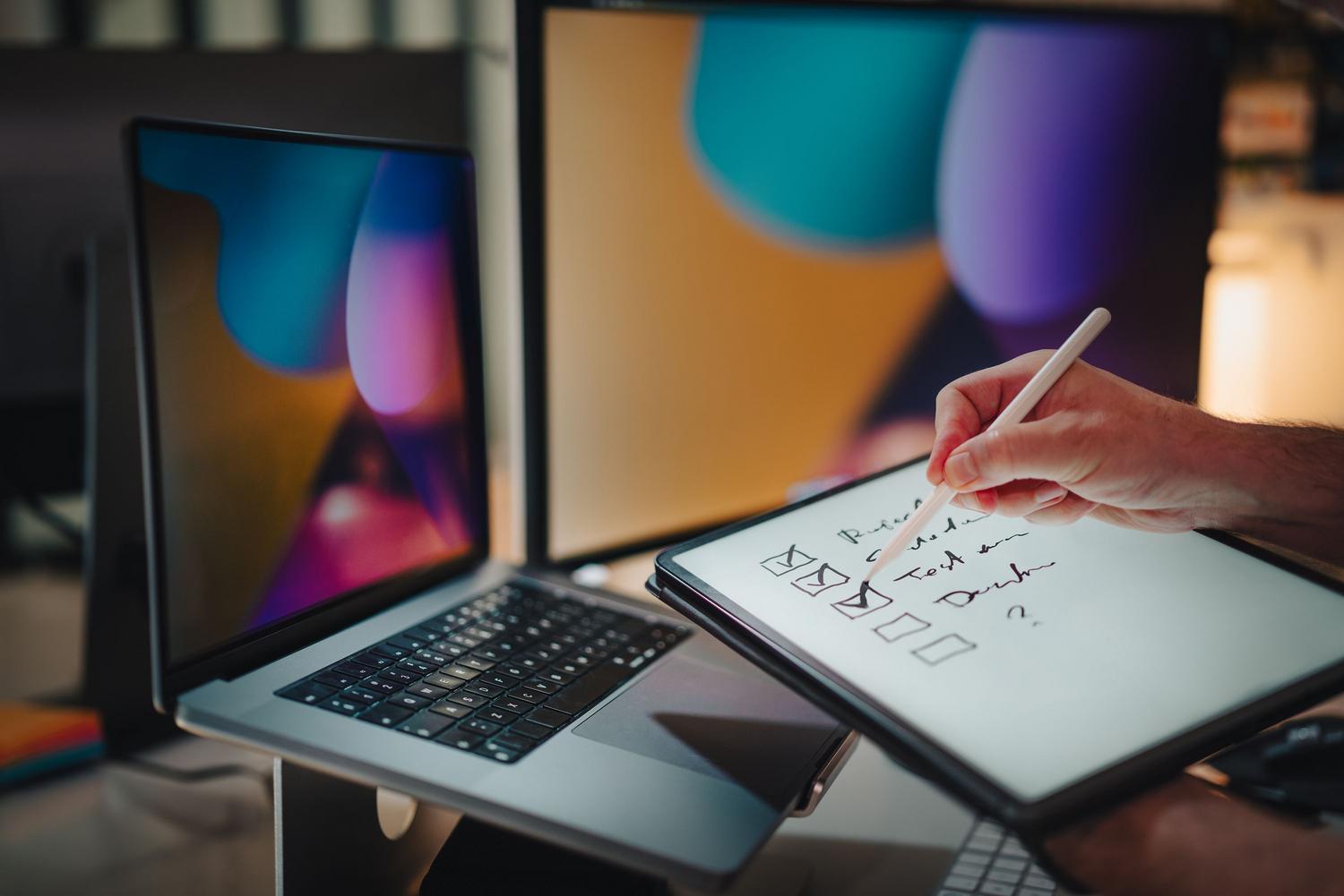 Uso de tablet con lápiz digital en un entorno de oficina moderno, destacando la versatilidad y compatibilidad multiplataforma de las herramientas de notas.