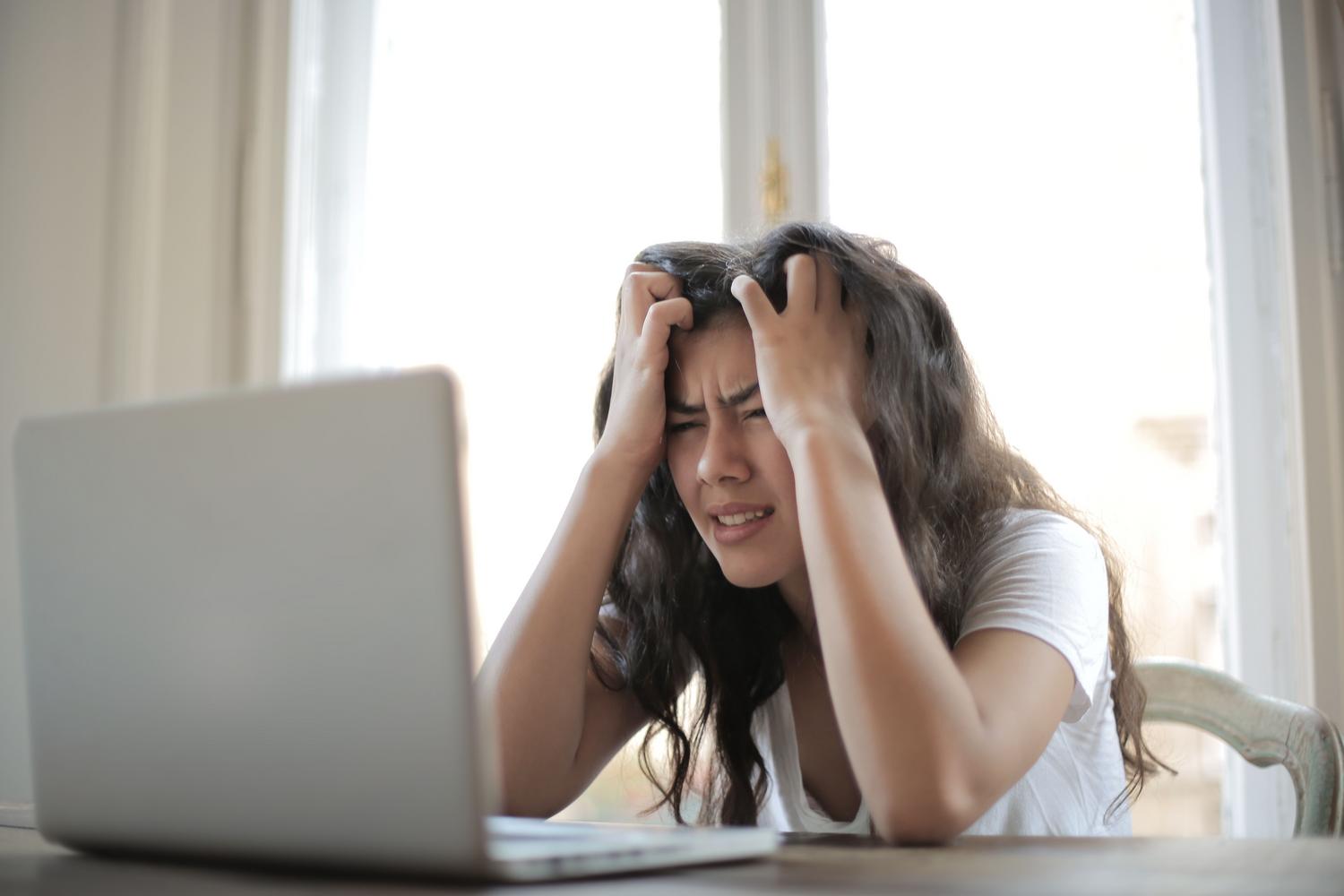 Mujer estresada trabajando en remoto, reflejando la frustración al encontrar OneDrive desconectado