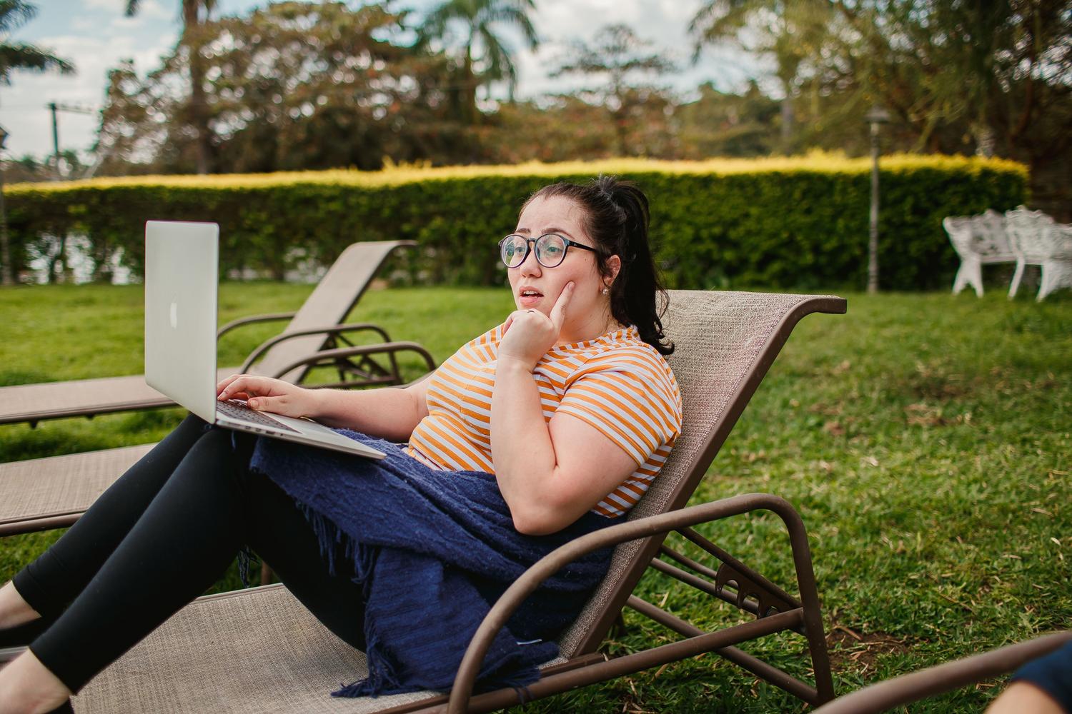 Libertad y ligereza de Linux Mint Mujer relajada usando su ordenador portátil en un jardín soleado, simbolizando la ligereza y libertad del sistema operativo.