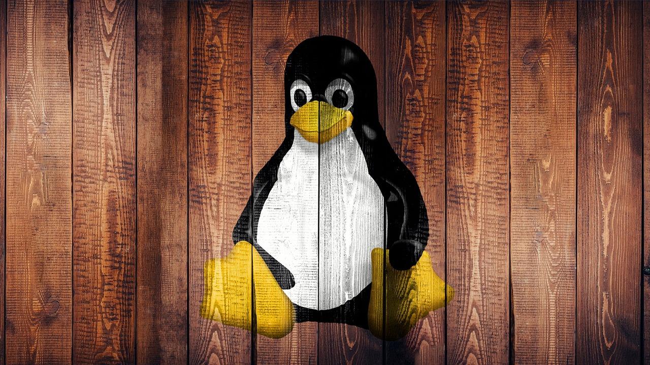 Transición a Linux Mint Laptop con el logotipo del pingüino de Linux en la pantalla, representando la transición al software libre.