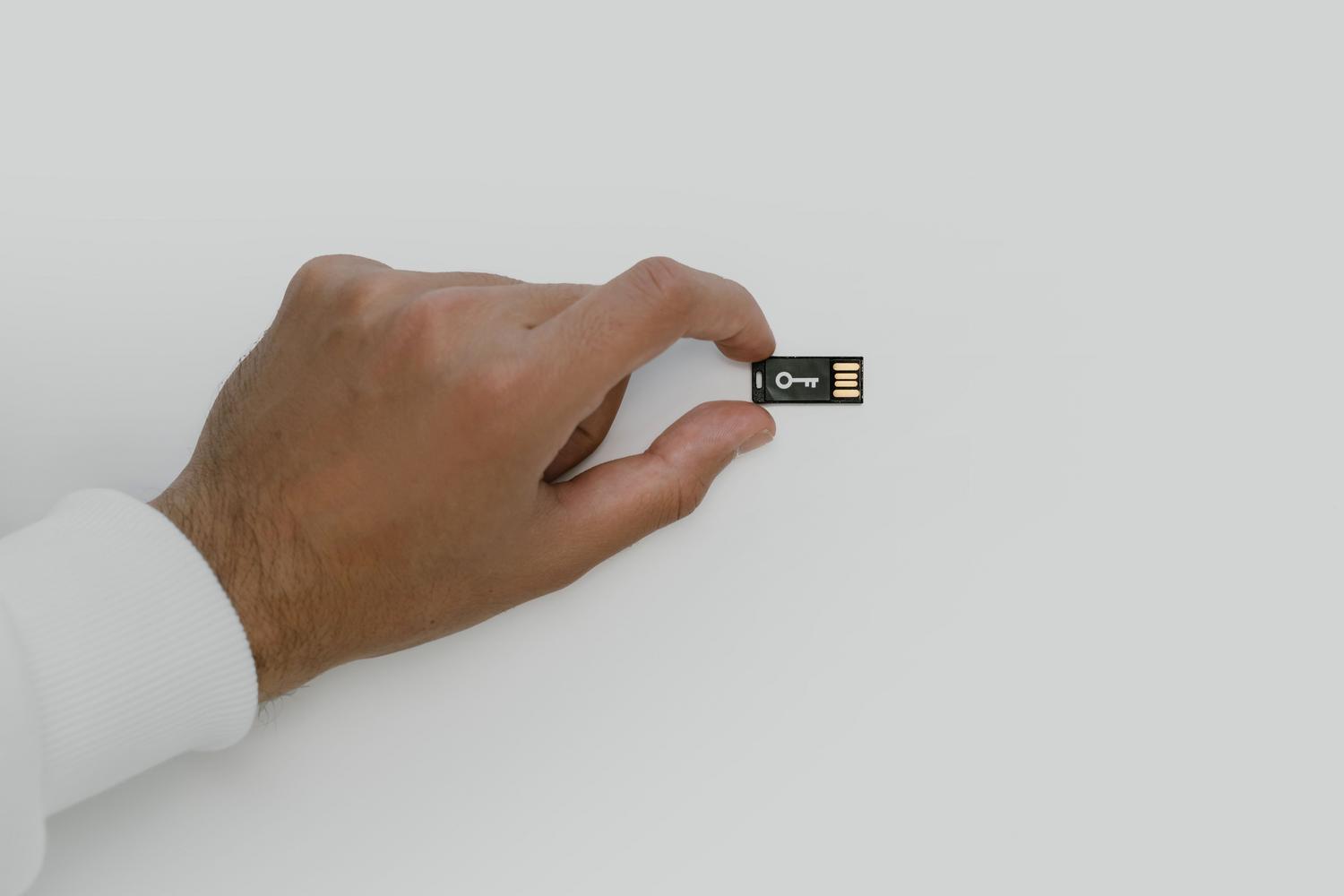 Mano sosteniendo una llave de seguridad física USB, representando la defensa contra el phishing.