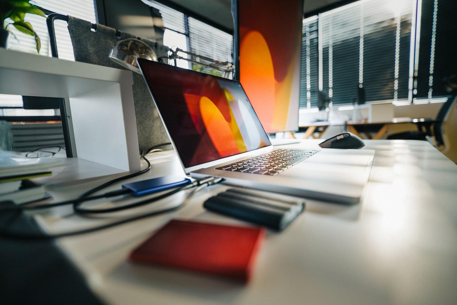 Espacio de trabajo moderno con portátil y unidades de almacenamiento externas, ideal para la sección de copias de seguridad.