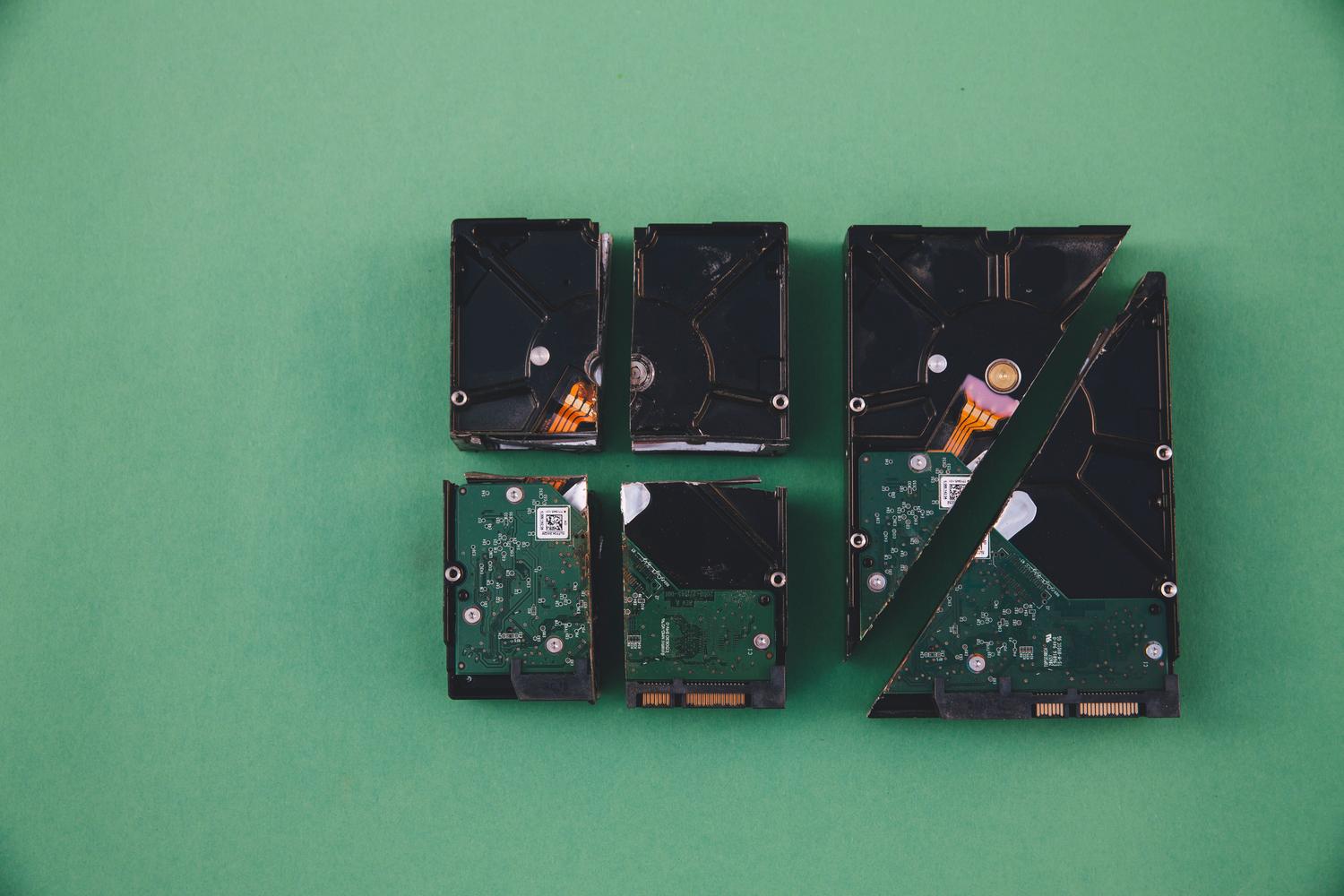 Discos duros dañados y rotos, ilustrando la destrucción física de datos para máxima seguridad.