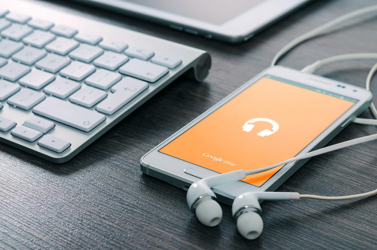 Prueba y escucha del tono de llamada personalizado Smartphone con auriculares en un escritorio para probar el tono de llamada