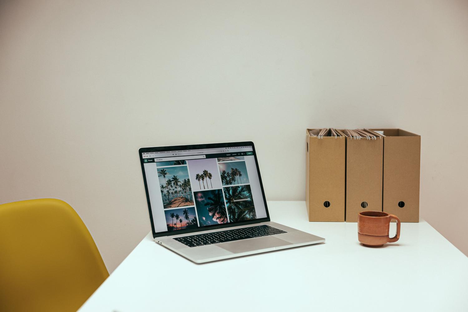 Espacio de trabajo moderno y limpio con un ordenador portátil y café, representando la productividad y el orden digital.