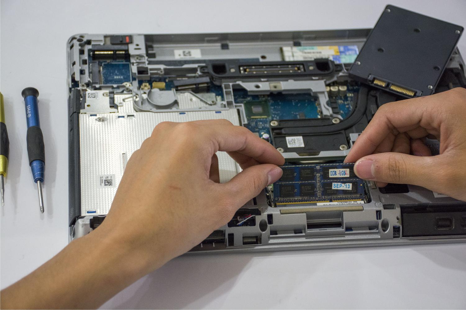 Tehničar instalira RAM u laptop, ilustrujući proces nadogradnje hardvera.