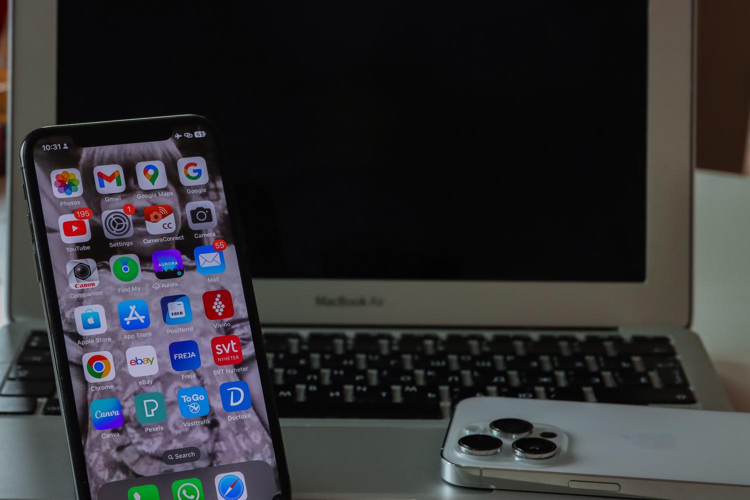 Un smartphone i un ordinador portàtil sobre un escriptori, representant el mètode avançat dinstal·lació dAPKs mitjançant ADB i cable USB.