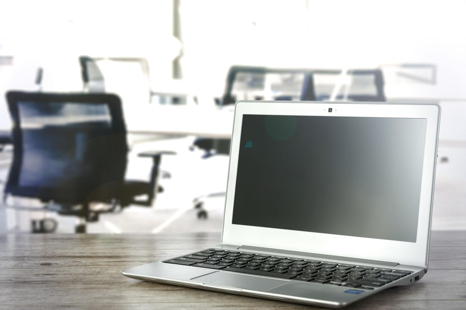 Portátil moderno en un entorno de oficina iluminado, ideal para ilustrar el sistema operativo Windows 11