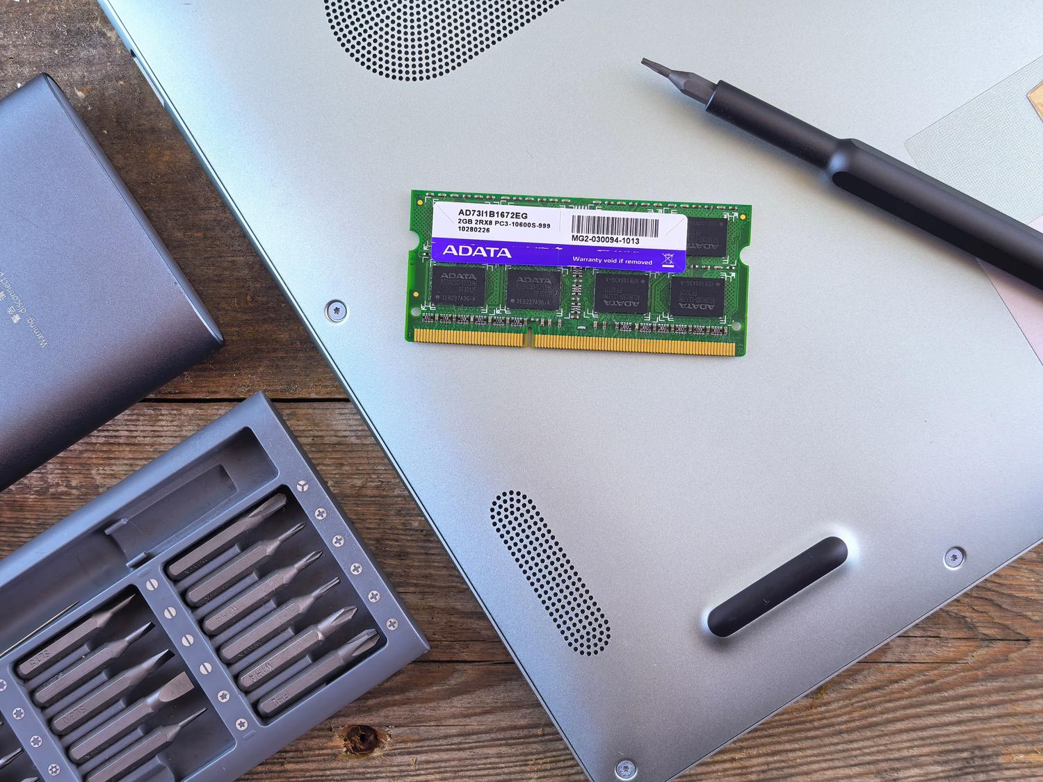Herramientas de precisión y módulo de RAM para el mantenimiento de un ordenador portátil