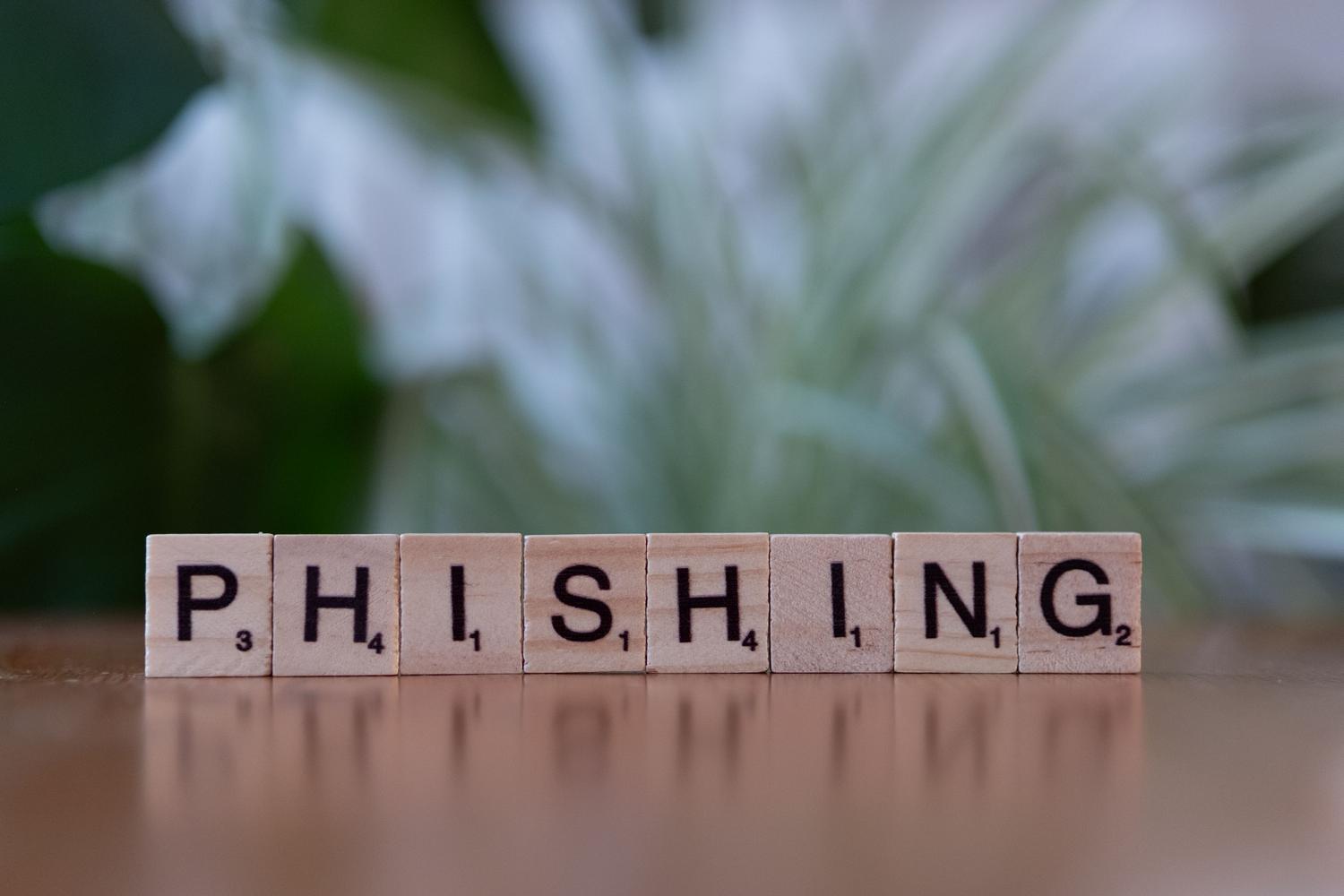 Lettere di legno che formano la parola "Phishing", a illustrare il concetto di inganno digitale utilizzato nelle truffe di verifica.