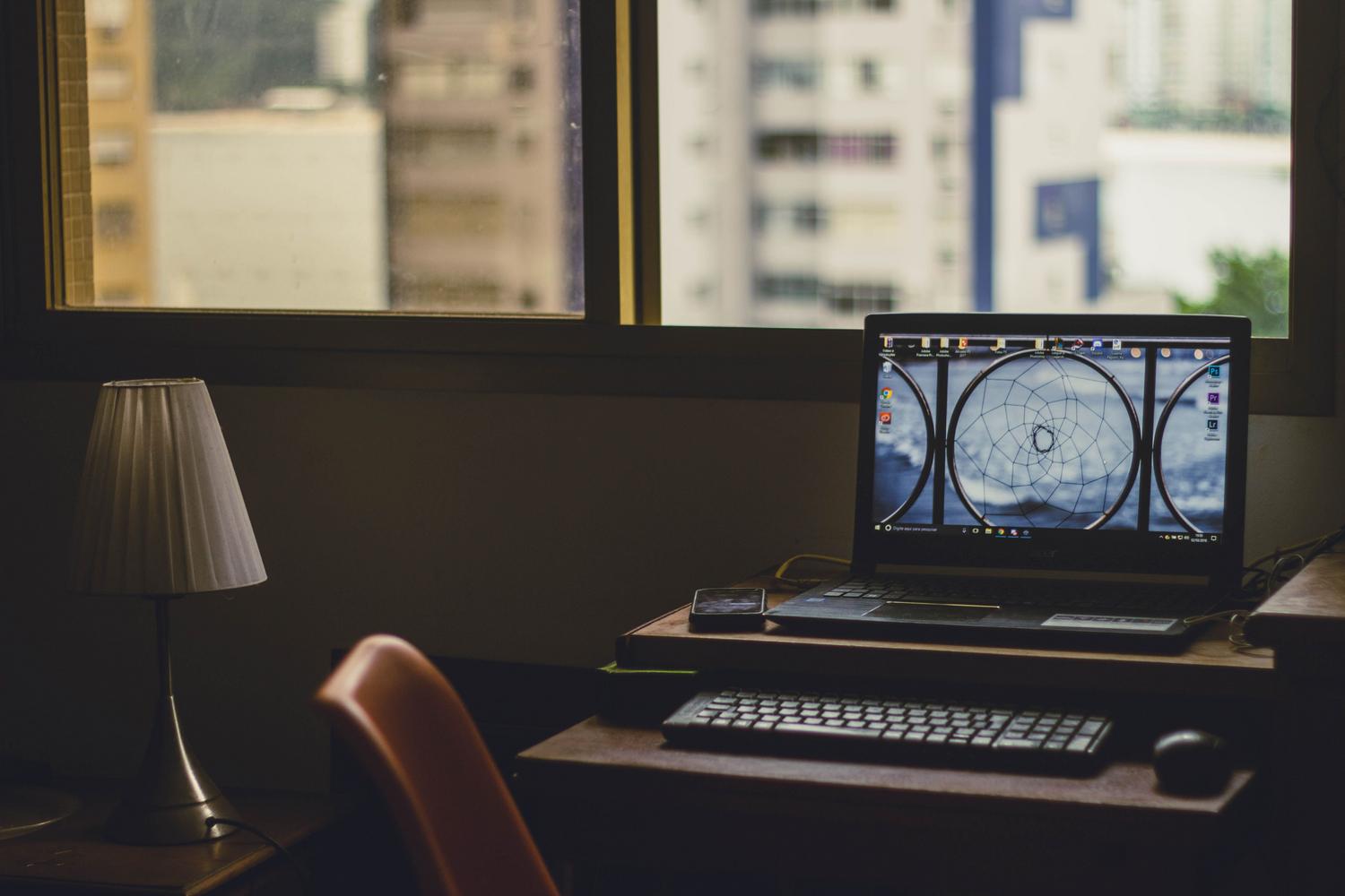 Espacio de trabajo doméstico con un ordenador portátil y ambiente tranquilo, representando al usuario cotidiano.
