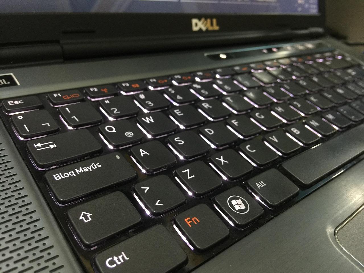 Primer plano de un teclado de portátil Dell Windows iluminado, simbolizando la interacción y el prompting en Gemini AI.
