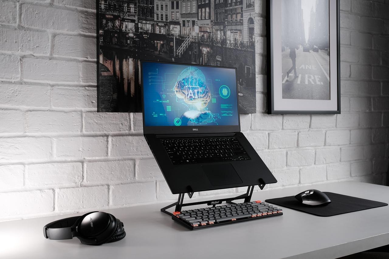 Estación de trabajo profesional con un portátil Dell mostrando una representación visual de inteligencia artificial en pantalla.