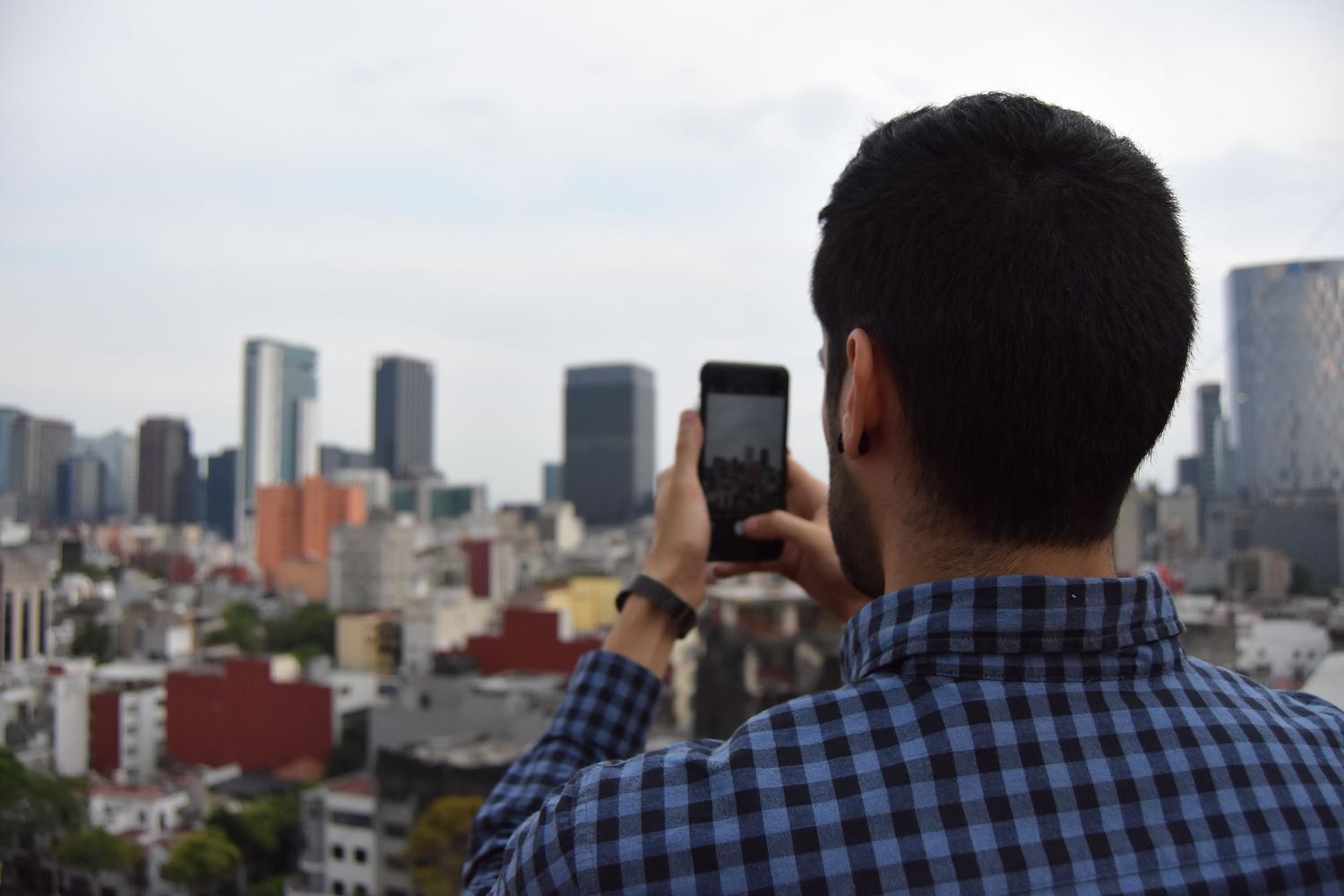 Hombre fotografiando el skyline de una ciudad, representando la evolución urbana y Street View