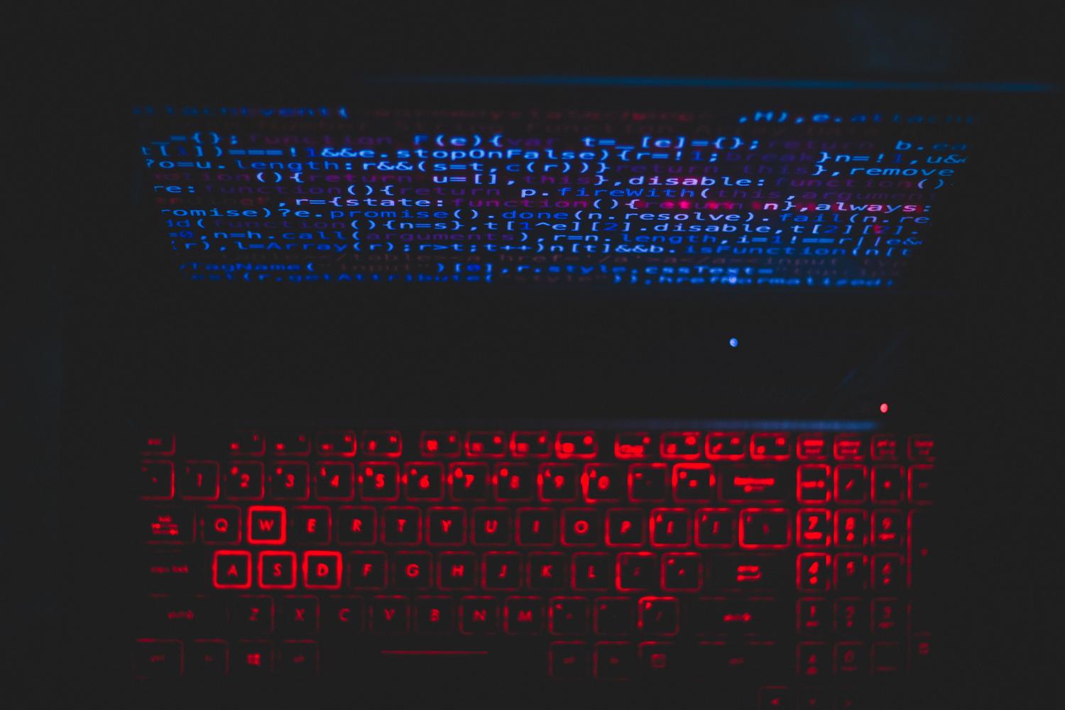 Teclado iluminado en rojo con código de programación en pantalla, simbolizando una alerta de seguridad o intrusión en el sistema.