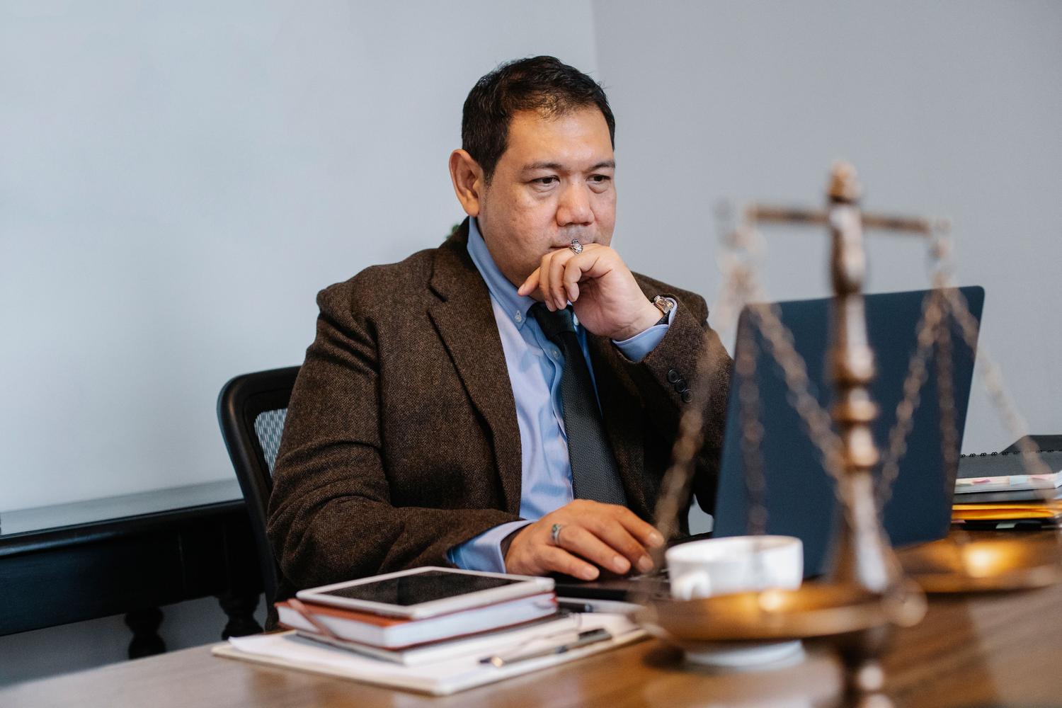Abogado analizando datos en un portátil en una oficina moderna, simbolizando la aplicación profesional del RegTech. Abogado analizando datos en un portátil en una oficina moderna, simbolizando la aplicación profesional del RegTech.